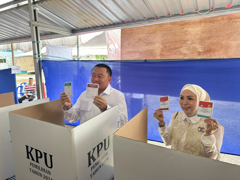 GUNAKAN HAK: Calon Gubernur Kalsel nomor urut 1, Muhidin menggunakan hak suara di TPS 11, Jalan Kayu Keruing. (Foto: Muhammad Oscar Fraby/Radar Banjarmasin)