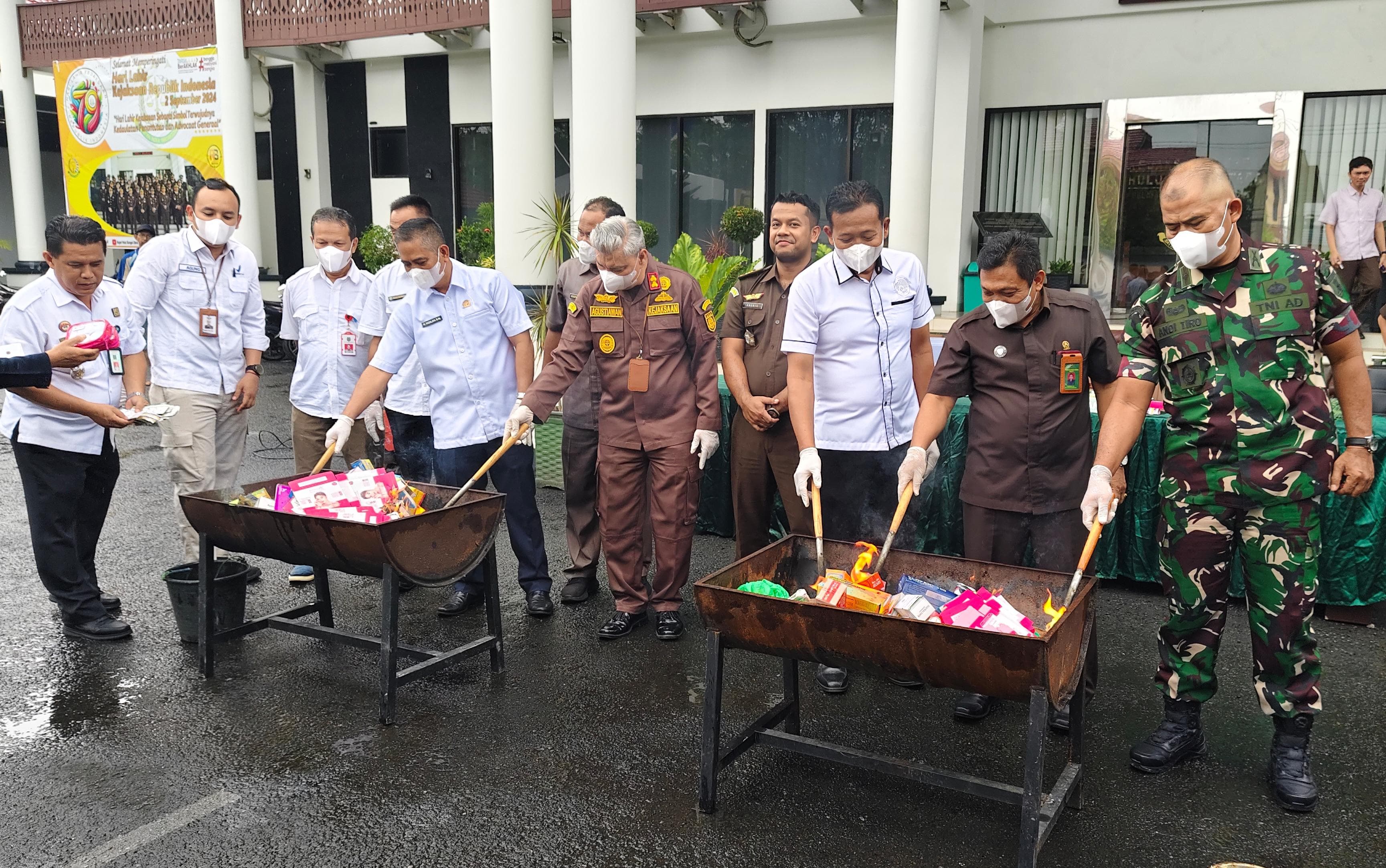 BARBUK: Pemusnahan barang bukti hasil kejahatan yang sudah inkrah di halaman Kantor Kejari HSU, Rabu (4/12/2024). (Foto: M.Akbar/Radar Banjarmasin)