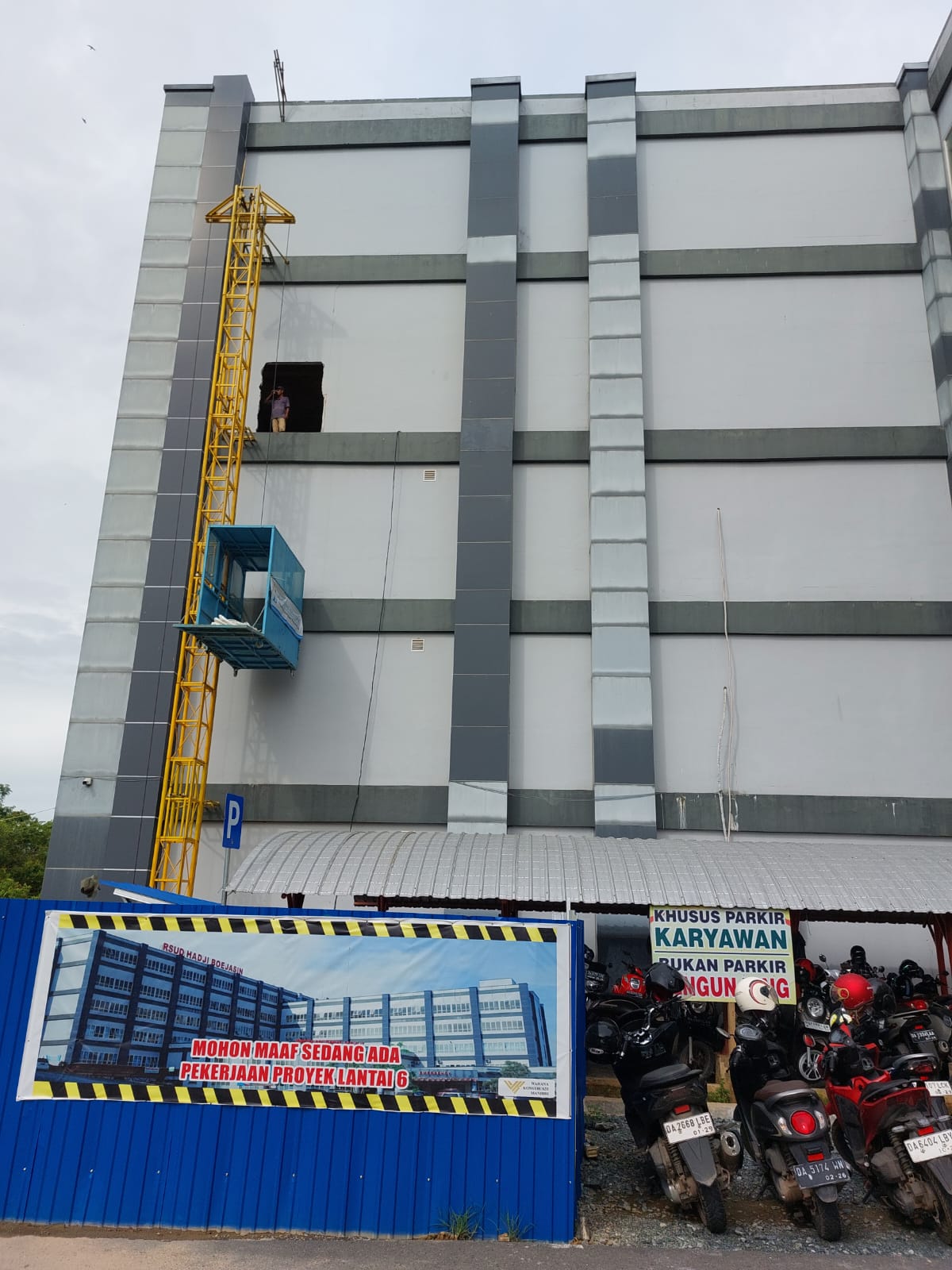 RENOVASI:Sejumlah pekerja menurunkan bahan bangunan dari lantai enam RSUD Hadji Boejasin Pelaihari yang sedang direnovasi.(Foto:Norsalim Yahya/Radar Banjarmasin)