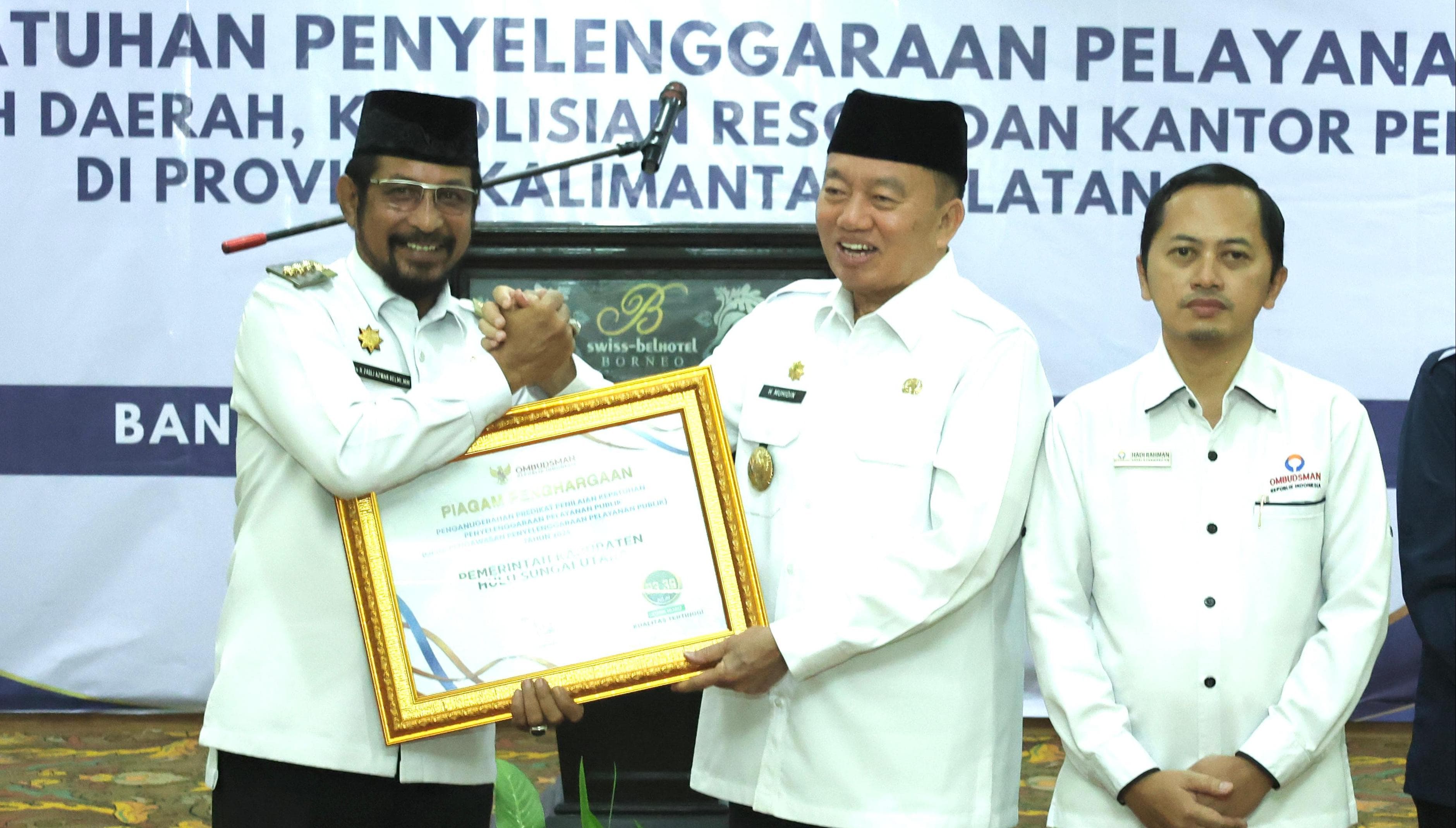 PRESTASI:Pj Bupati HSU, Zakly Asswan menerima penghargaan Ombudsman RI yang diserahkan Plt Gubernur Kalsel, H Muhidin di Banjarmasin, Rabu (11/12/2024).