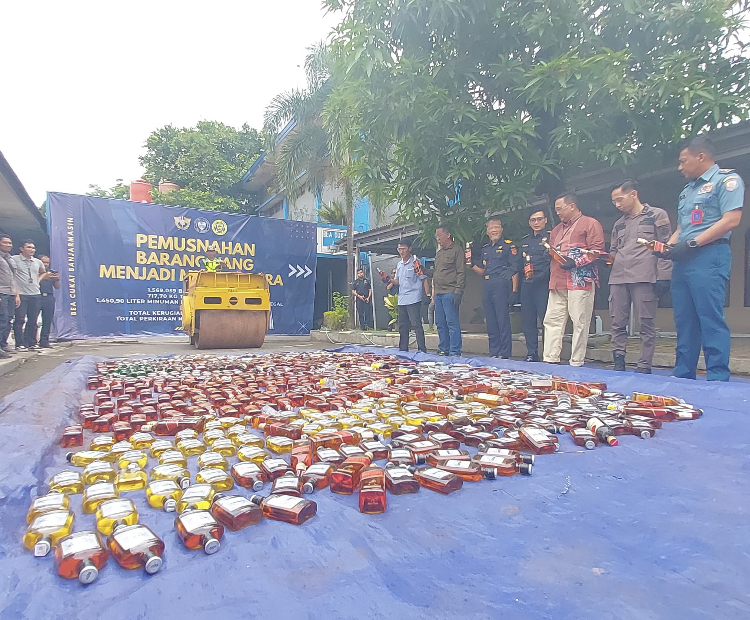 BARANG ILEGAL: Botol-botol miras ilegal dihancurkan dengan dilindas stum.
