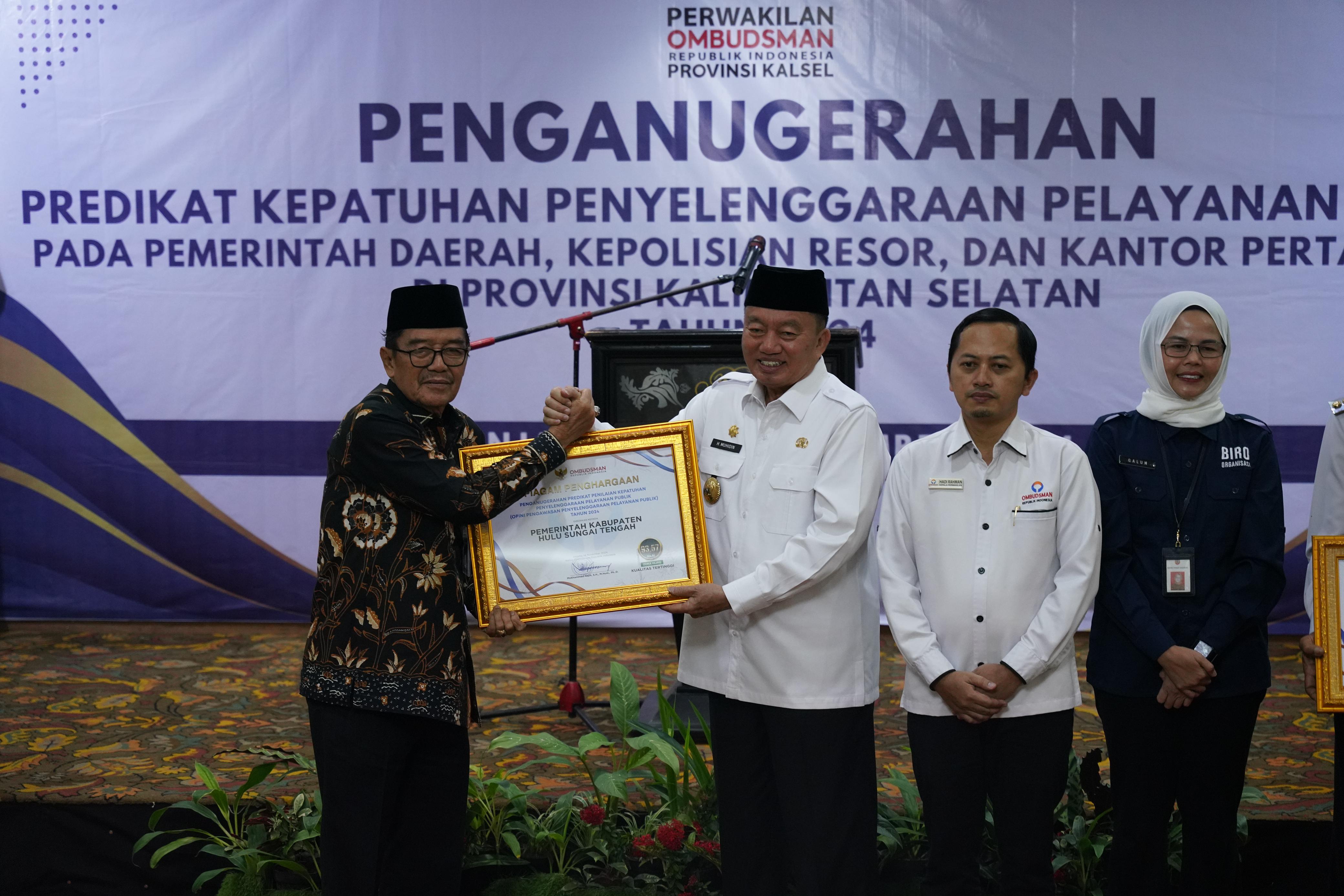 MEMBANGGAKAN:Wakil Bupati HST, H Mansyah Sabri menerima piagam penghargaan Ombudsman RI dari Plt Gubernur Kalsel, Muhidin, Rabu (11/12/2024).