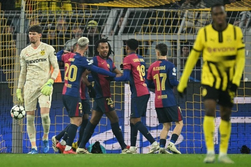 MERAYAKAN: Para pemain Barcelona merayakan gol pembuka yang dicetak Raphinha pada pertandingan Liga Champions antara Borussia Dortmund vs Barcelona di Dortmund, Kamis (12/12) dini hari WIB.
