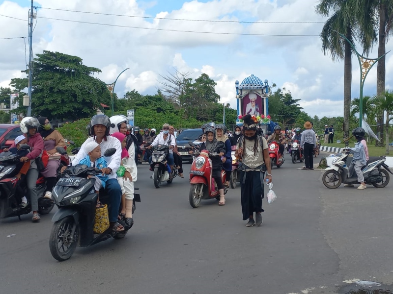 TABAH: Seorang peziarah asal Lumajang, Jawa Timur berjalan di tepian Jalan Landasan Ulin, Banjarbaru untuk mengadiri haul KH Muhammad Zaini bin Abdul Ghani di Sekumpul, Martapura, Minggu (5/1/2025).