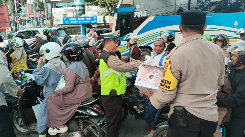 BAGIKAN MAKANAN: Jemaah Haul Guru Sekumpul singgah di batas kota, Jalan Ahmad Yani km 6, menerima pembagian makanan dan minuman gratis, Ahad (5/1).