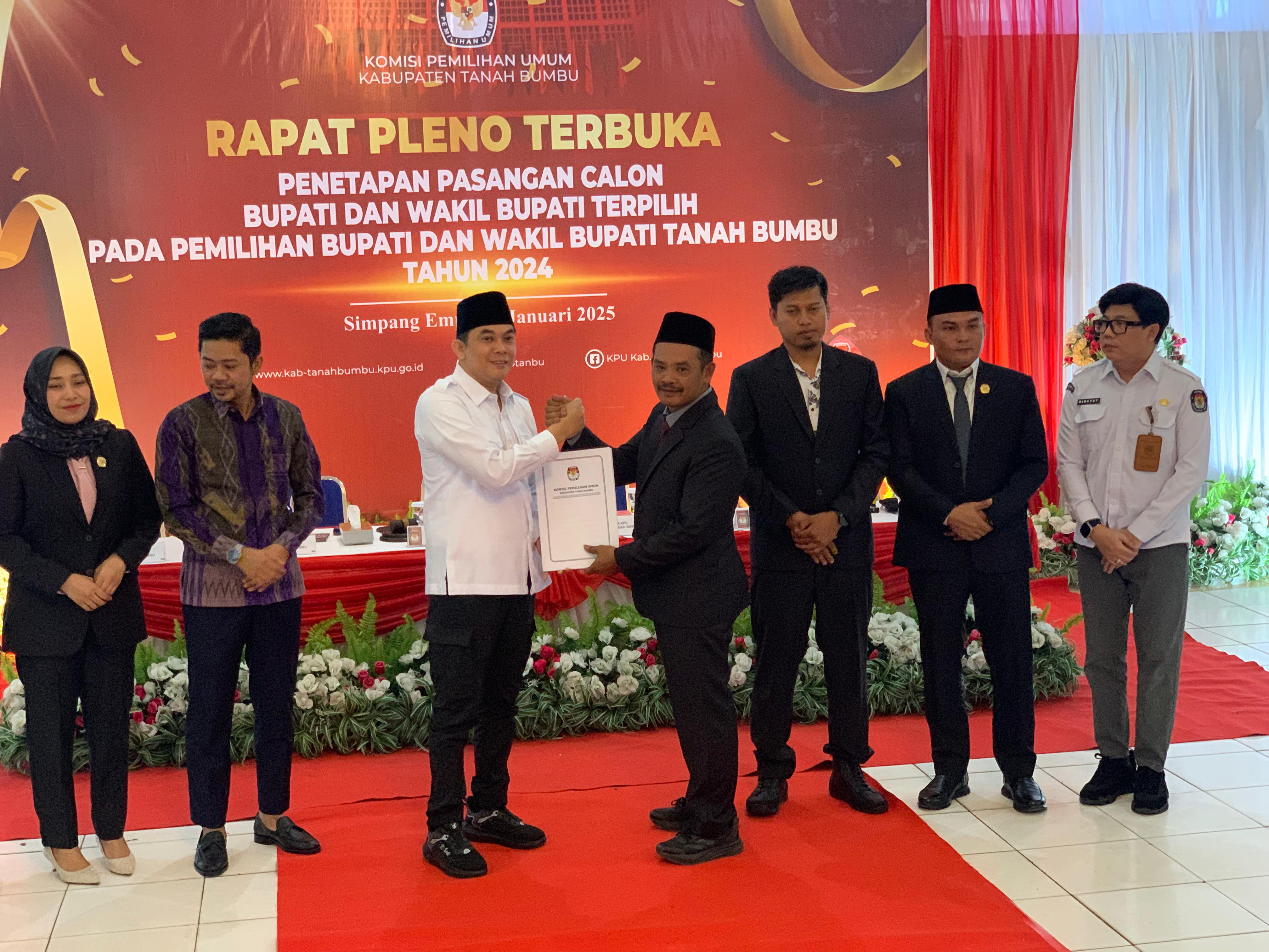 PENYERAHAN: Ketua KPU Tanah Bumbu Puryadi menyerahkan surat keputusan penetapan bupati terpilih kepada Andi Rudi Latif dalam rapat pleno, Kamis (9/1). (Foto: Zulqarnain/Radar Banjarmasin)