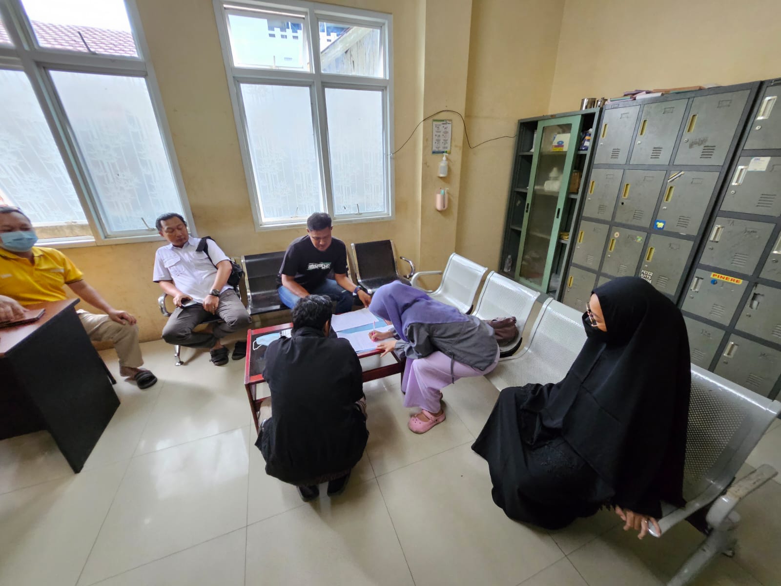 MENGIKHLASKAN: Perwakilan keluarga menandatangani surat perjanjian penolakan untuk dilakukan autopsi di kamar pemulasaraan RSDU Ulin Banjarmasin.