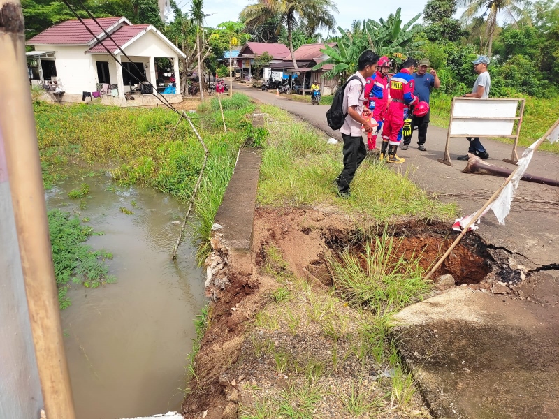 CEK LOKASI: Petugas BPBD Kabupaten Banjar memeriksa tanah ambles di Desa Mandikapau, Kecamatan Karang Intan. (BPBD BANJAR UNTUK RADAR&nbsp;BANJARMASIN)