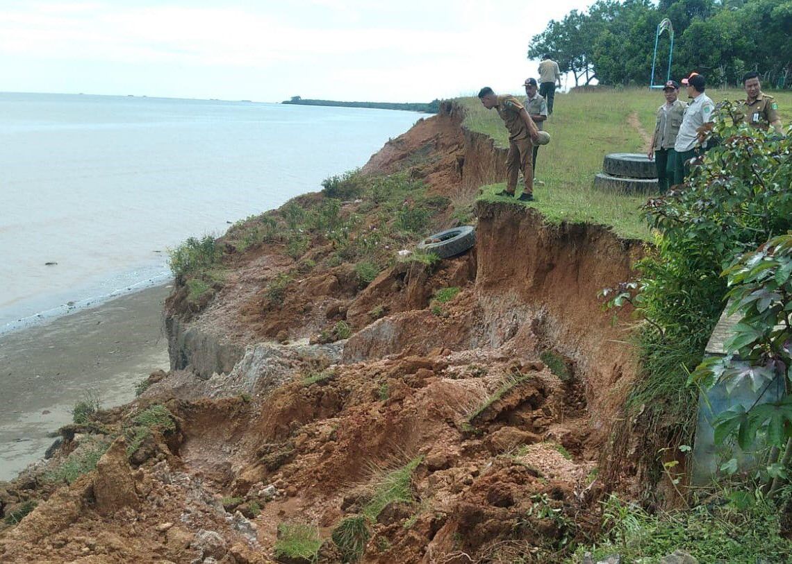 TINJAU: Petugas BPBD meninjau lokasi abrasi di Pantai Sungai Dua Laut, Tanah Bumbu, beberapa waktu lalu. Kondisi tebing kini terkikis semakin parah. (Foto: BPBD Tanah Bumbu untuk Radar)