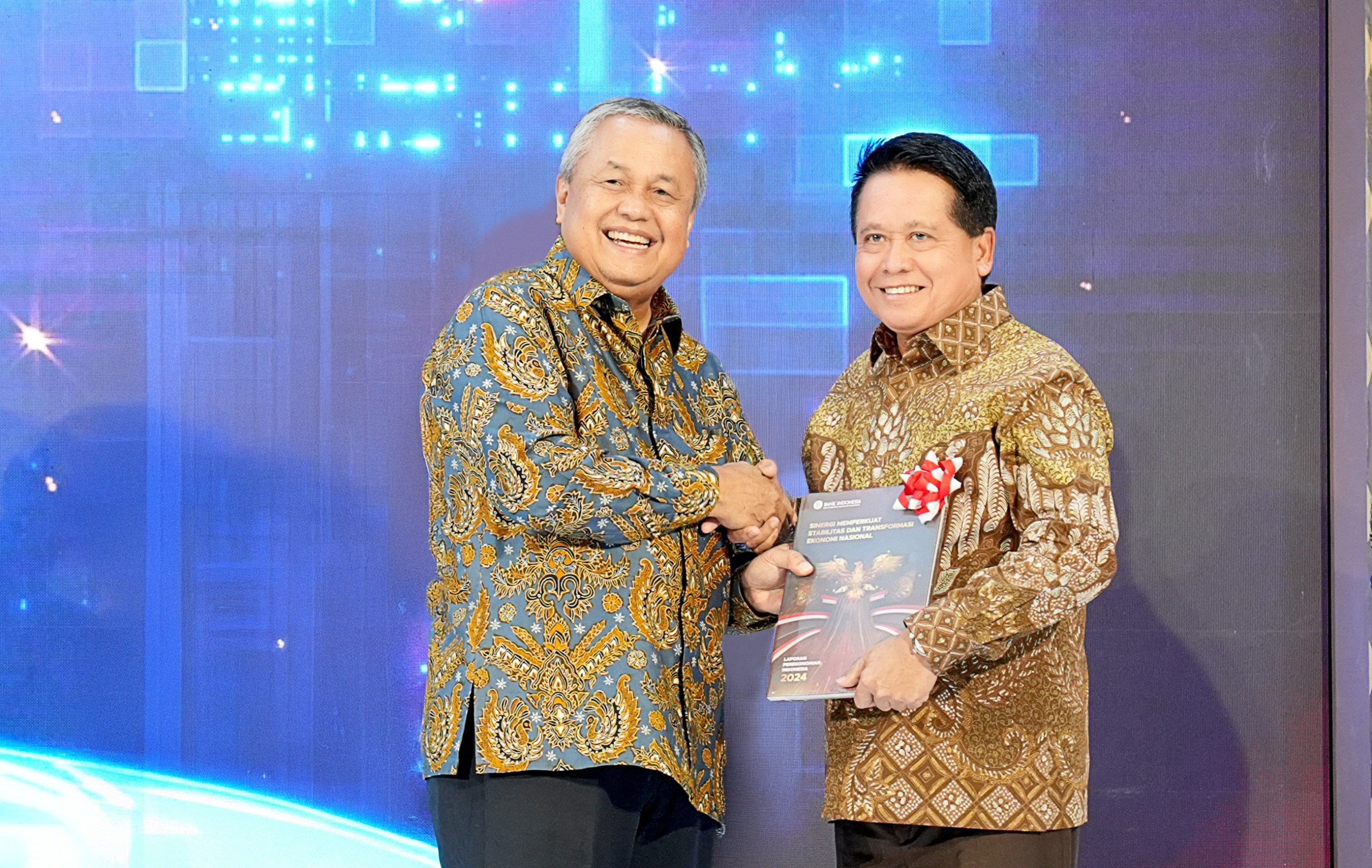 JABAT TANGAN:Direktur Utama BSI, Hery Gunardi (kanan) menerima buku Laporan Perekonomian Indonesia 2024 dari Gubernur BI, Perry Warjiyo (kanan) di Kantor Bank Indonesia di Jakarta (22/1/2025).