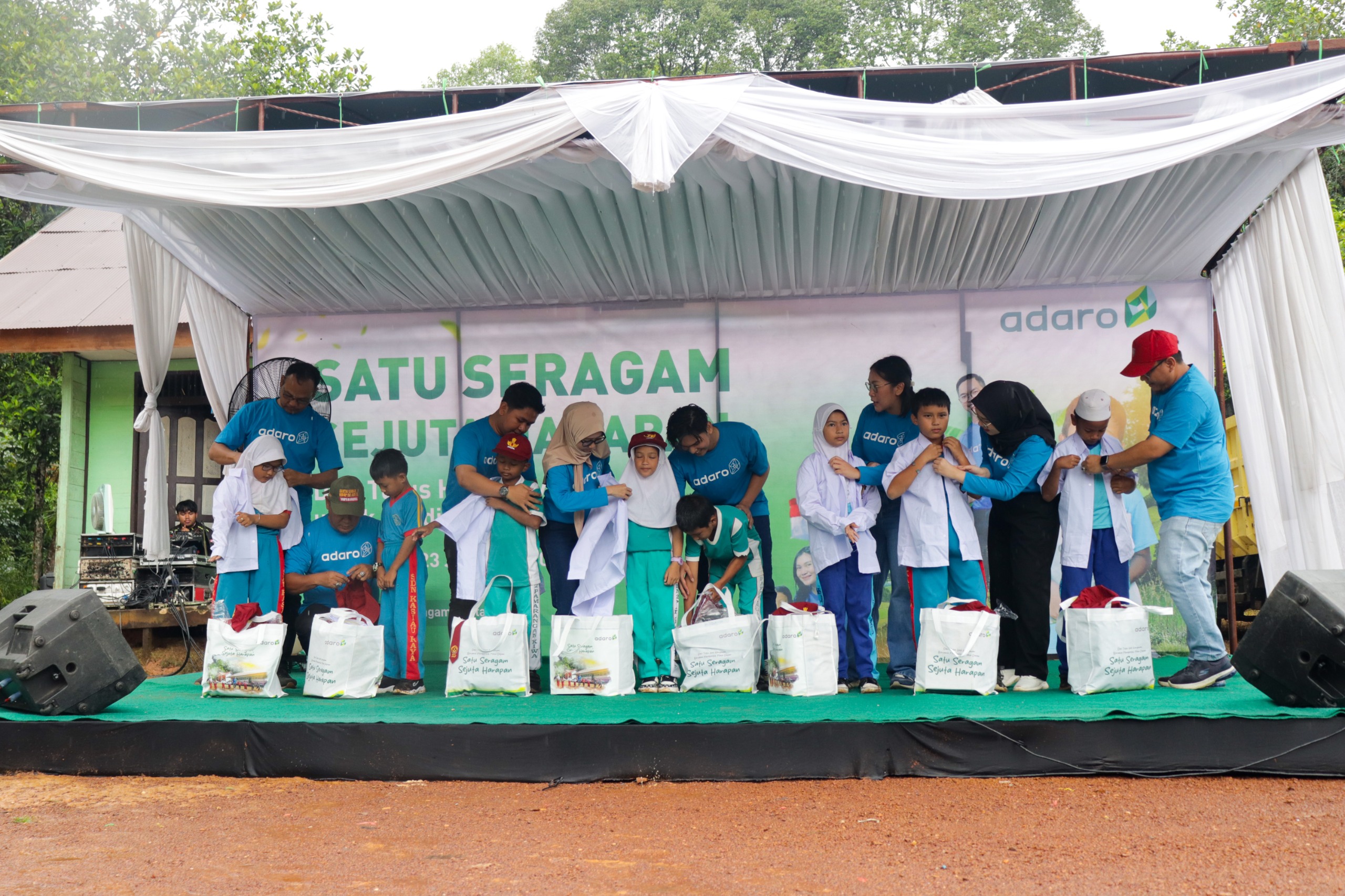 SERAGAM BARU: Para karyawan Adaro mengenakan seragam sekolah ke siswa SDN 2 Pamarangan Kiwa secara simbolis.(foto-foto:YABN untuk Radar Banjarmasin)