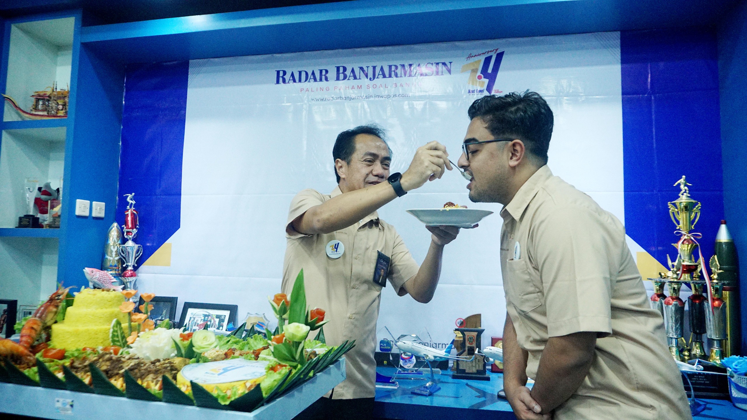 POTONG TUMPENG: Direktur Radar Banjarmasin H Achmad Suriansyah memberikan potongan tumpeng kepada salah satu karyawan Radar Banjarmasin.