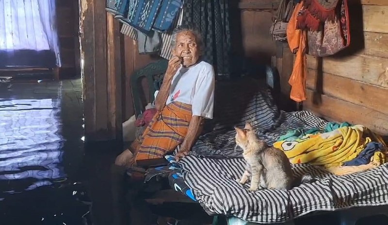 BERTAHAN: Arniah (80), korban banjir di Pengayuan, Kelurahan Landasan Ulin Selatan, memilih bertahan di rumahnya meski air sudah selutut orang dewasa.