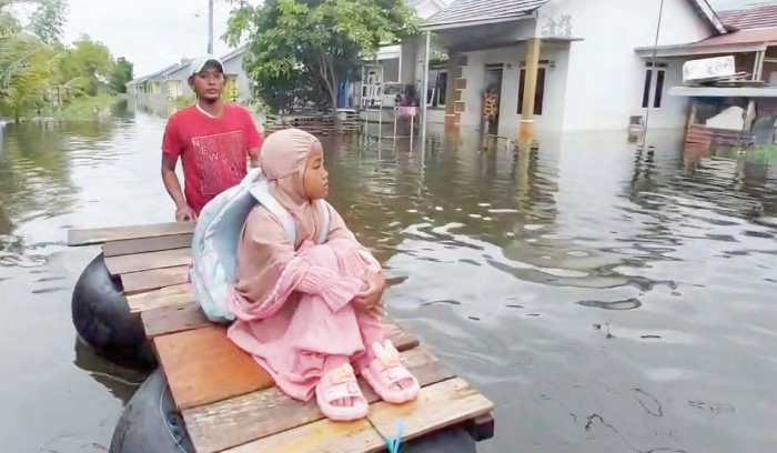 PAKAI BAN: Warga Perumahan Perumahan Berkat Alam Sekumpul, Bincau, Martapura mengantar anak berangkat ngaji pakai rakit seadanya.