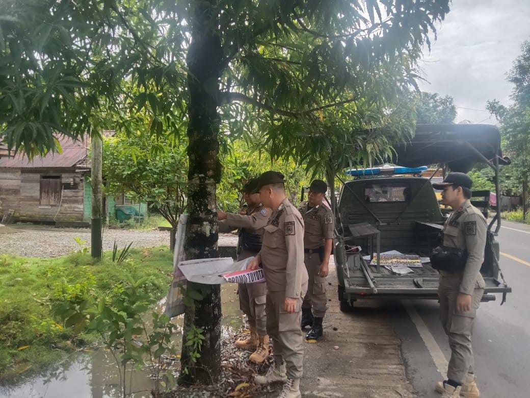 CABUT: Satpol PP dan Damkar Kabupaten HSS saat membongkar spanduk yang tidak berizin dan melanggar perda.(Foto: Satpol PP dan Damkar HSS untuk Radar Banjarmasin)