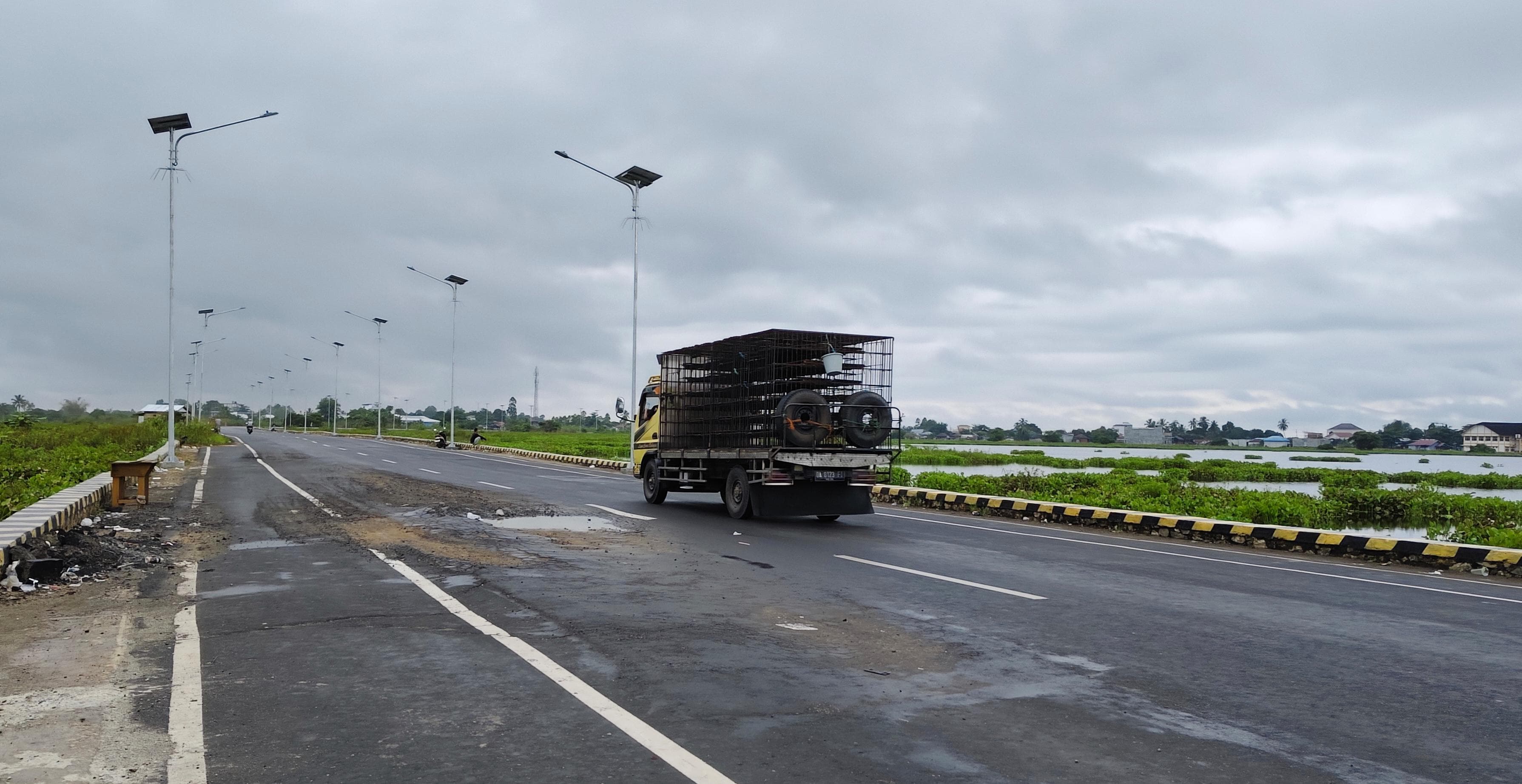 MENGHINDAR: Sebuah truk mini berusaha menghindari lubang di Jalan Bypass Bayur-Panangkalaan Amuntai.