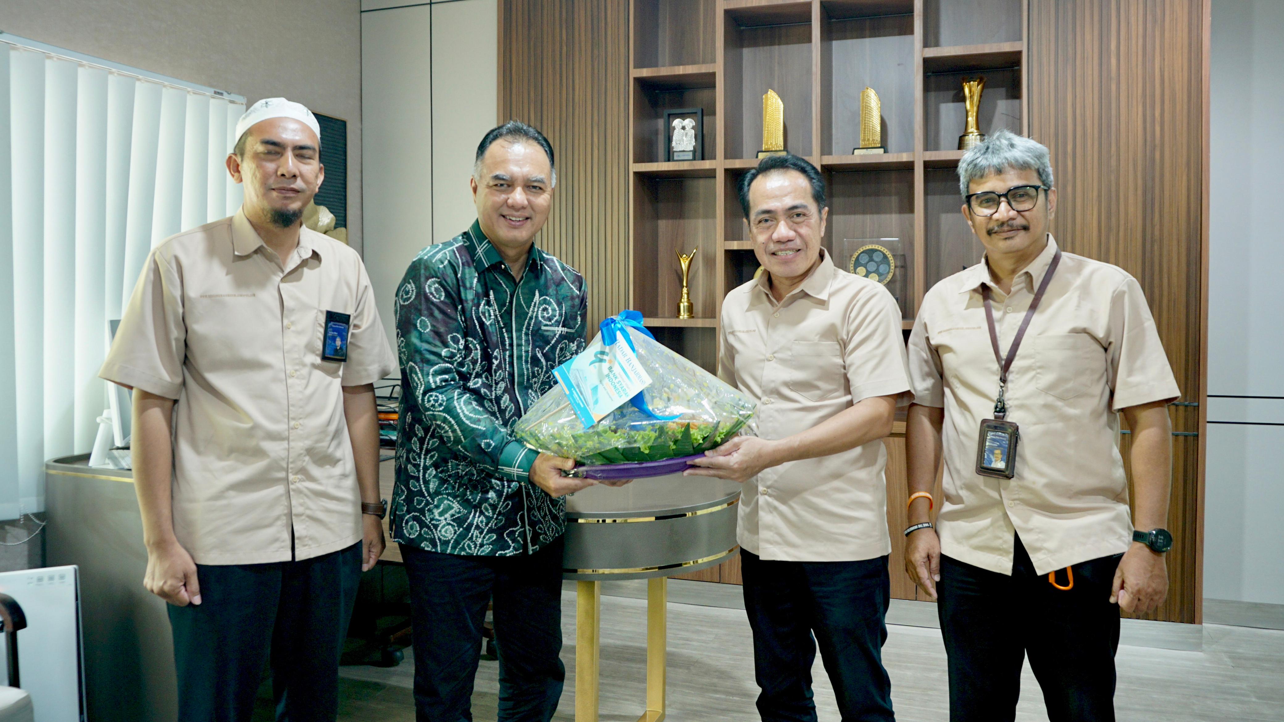 SUKSES SELALU: Direktur Utama Radar Banjarmasin, H Suriansyah Achmad menyerahkan nasi tumpeng kepada RCEO BSI Regional 9/Kalimantan, Ricky Rikardo, Senin (3/2/2025).