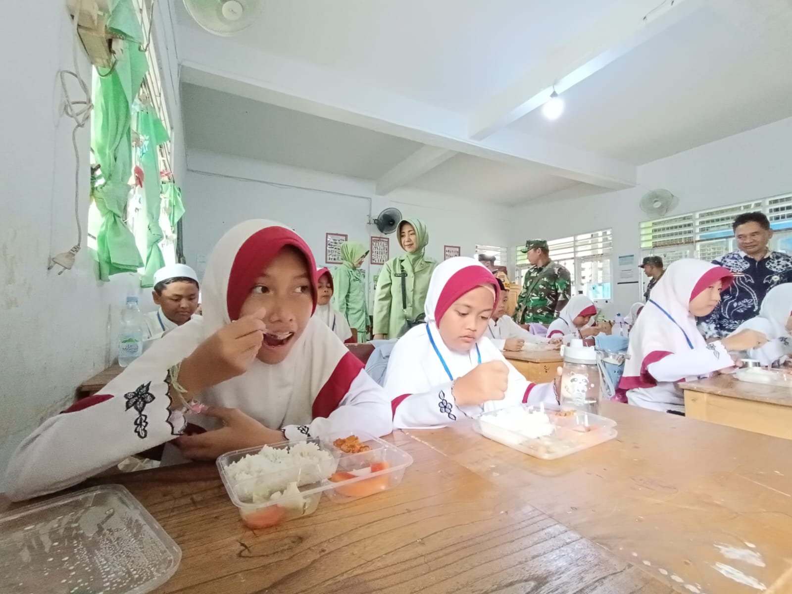 UJI COBA: Pelajar SDN 4 Kandangan Kota menyantap menu makanan saat uji coba perdana program MBG dilakukan Kodim 1003/HSS.
