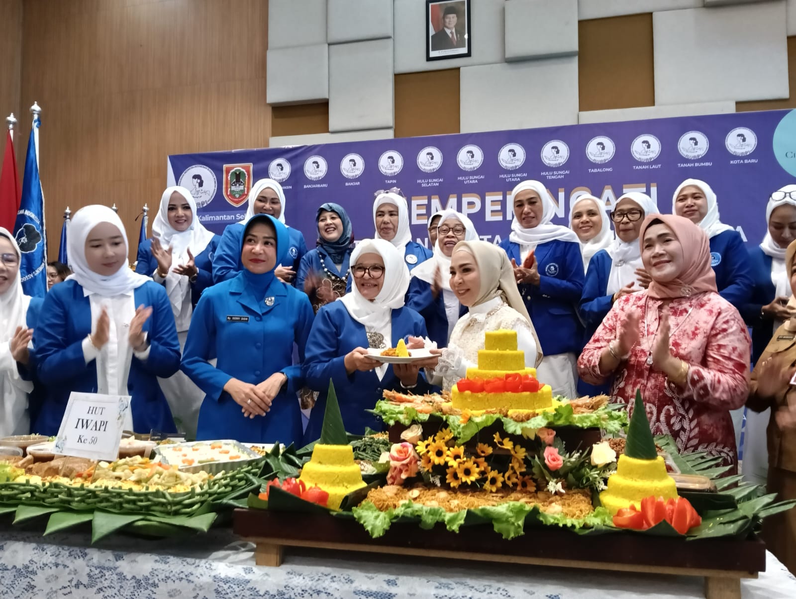 ULTAH: Ketua DPD IWAPI Kalsel, Hj Shinta Laksmi Dewi menyerahkan nasi tumpeng kepada Ketua TP PKK Kalsel, Hj Fathul Jannah Muhidin di momen HUT ke-50 IWAPI di Ciputra Hospital, Selasa (11/2/2025).