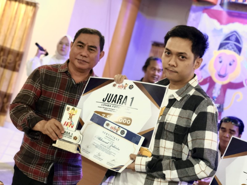 PEMENANG: Ketua PWI Kalsel, Zainal Helmi menyerahkan hadiah kepada pemenang Lomba Fotografi HPN 2025, Ahmad Zakirin.