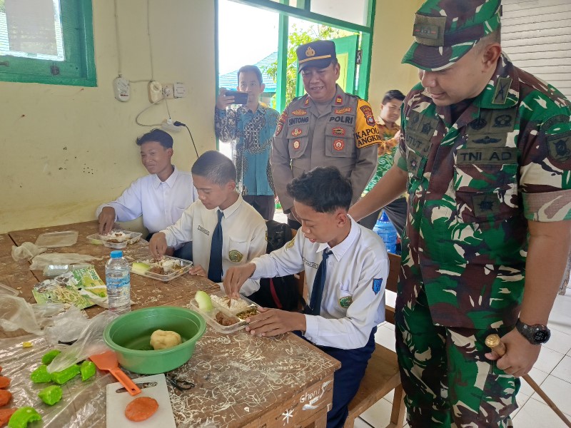 UJI COBA MBG : Pelajar MTsN 3 HSS menyantap menu makanan saat uji coba kedua program MBG dilakukan Kodim 1003/HSS.