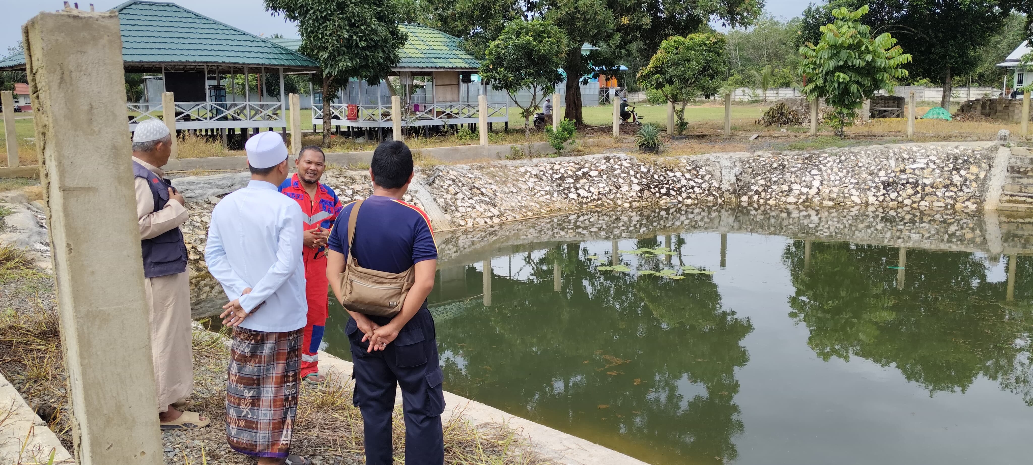 MUSIBAH: Anggota Tim Damkar Dinas Satpol PP dan Damkar HSU, berada di lokasi kolam dimana korban ditemukan tenggelam. (Foto: Damkar HSU)