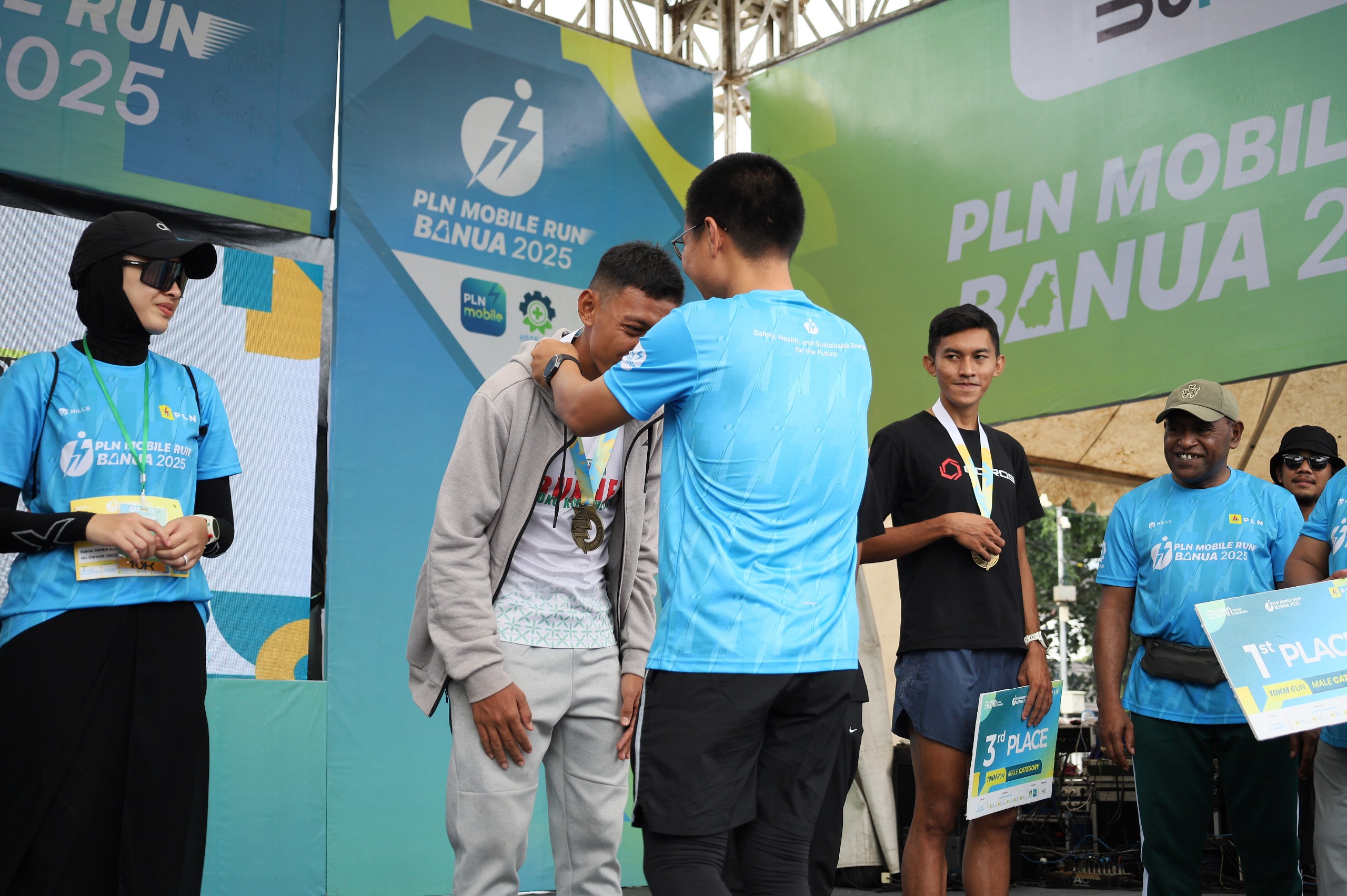 PRESTASI:General Manager PLN UID Kalselteng, Ahmad Syauki mengalungkan medali kepada Muhammad Adi Saputra, Juara 1 kategori 10K Male PLN Mobile Run Banua 2025.