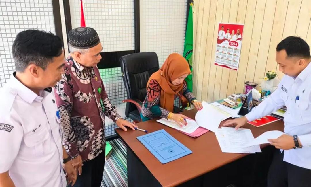 SEDERHANA:BPKAD HSU menyerahkan hibah aset disaksikan Kepala Kantor Kemenag HSU, Hj Nahdiyatul Husna, di ruang kerjanya.(Foto: Kantor Kemenag HSU)