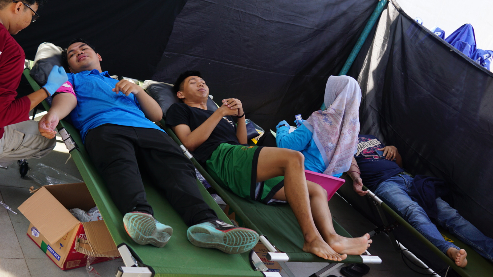 PASANG ALAT: Petugas memasangkan jarum dan peralatan pengambilan darah ke pendonor.