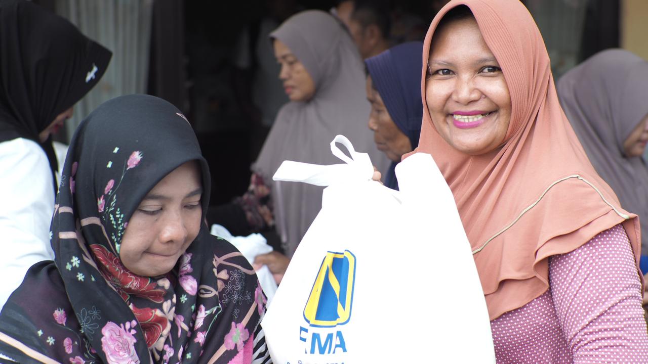 BERKAH: Salah seorang ibu yang terlihat bahagia mendapatkan paket sembako murah