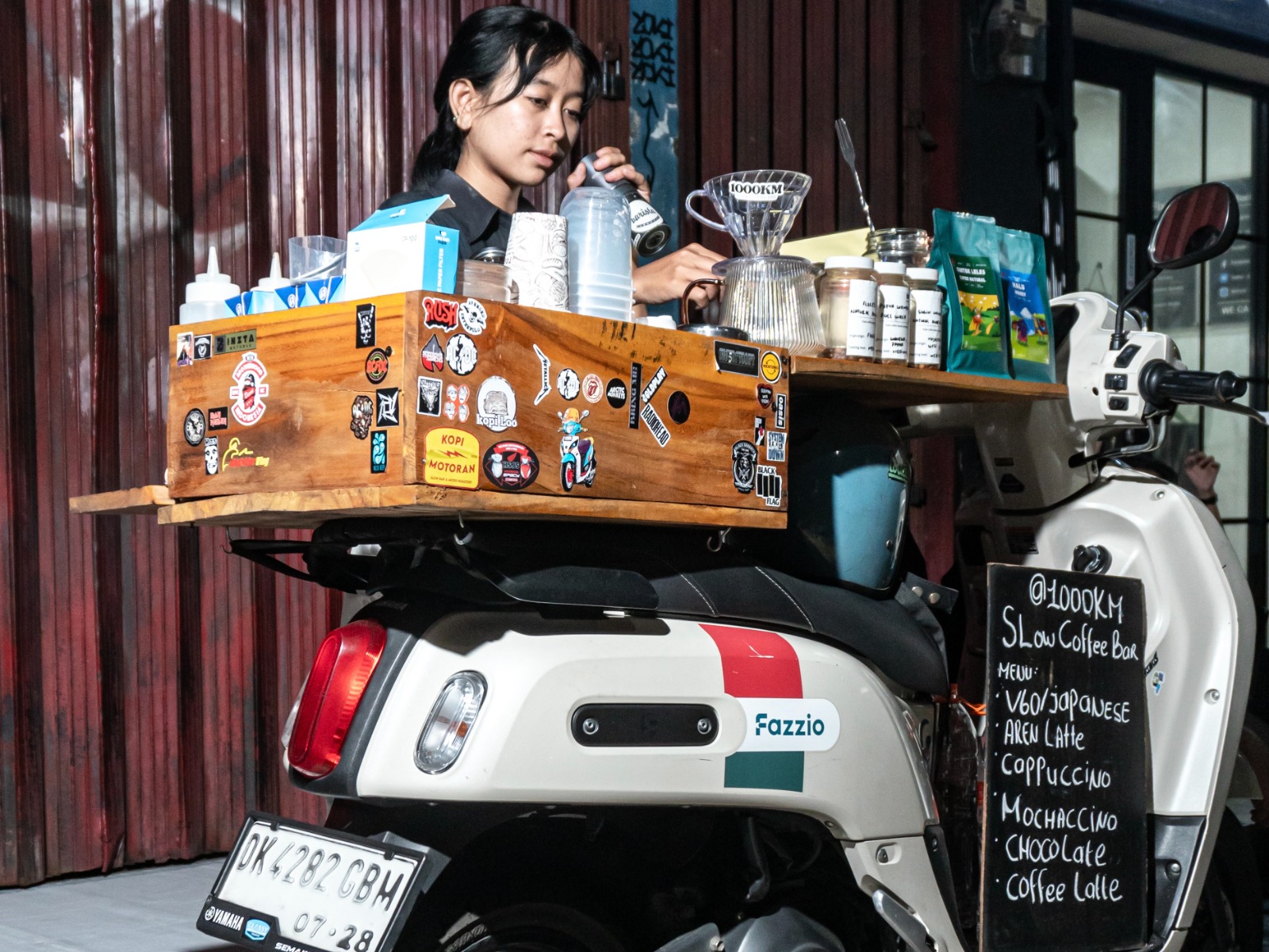 LAYANI PEMBELI: Caroline meracik kopi di atas Yamaha Fazzio yang dikendarainya dari Pulau Bali ke Depok.(foto-foto:PT YIMM)