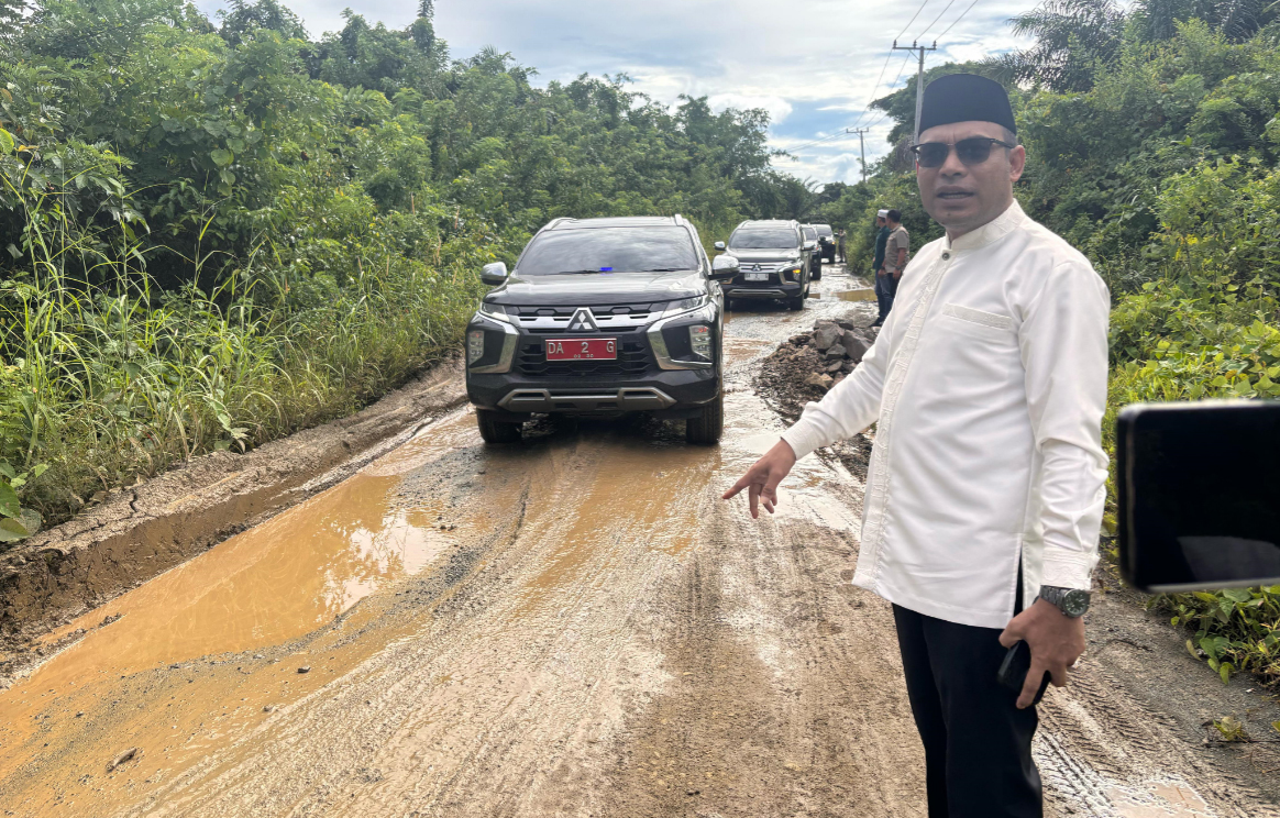PRIHATIN: Wabup Kotabaru Syairi Mukhlis turun mengecek jalan becek saat menuju ke Sampanahan. (Foto: Prokopim Kotabaru)