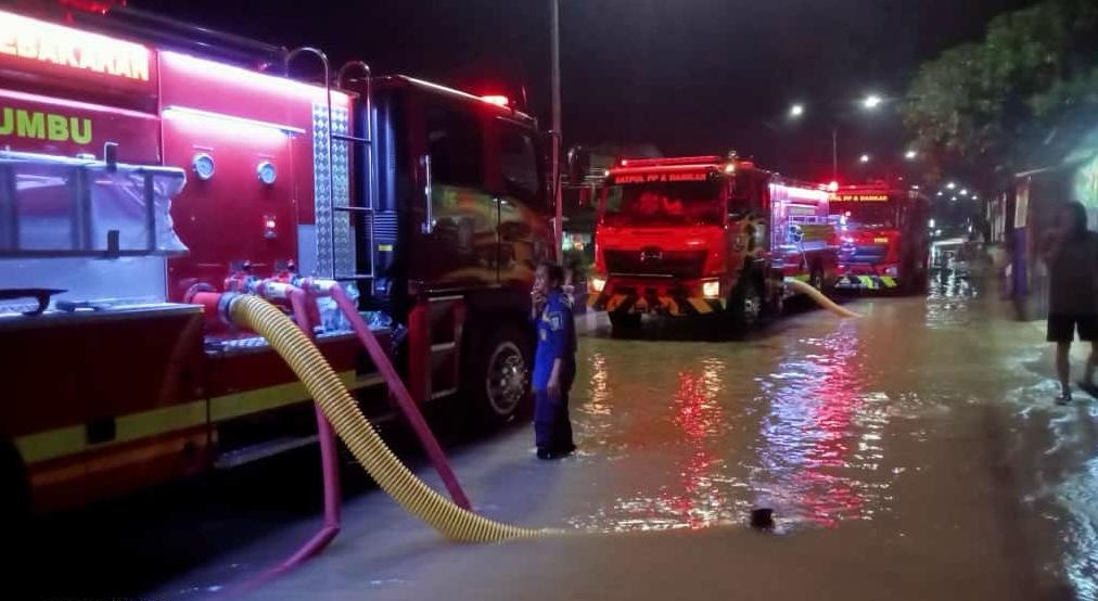 SEDOT AIR: Petugas Damkar Tanah Bumbu menyedot genangan air di Simpang Empat akibat hujan deras dan drainase tersumbat. (Foto: BPBD Tanah Bumbu untuk Radar)