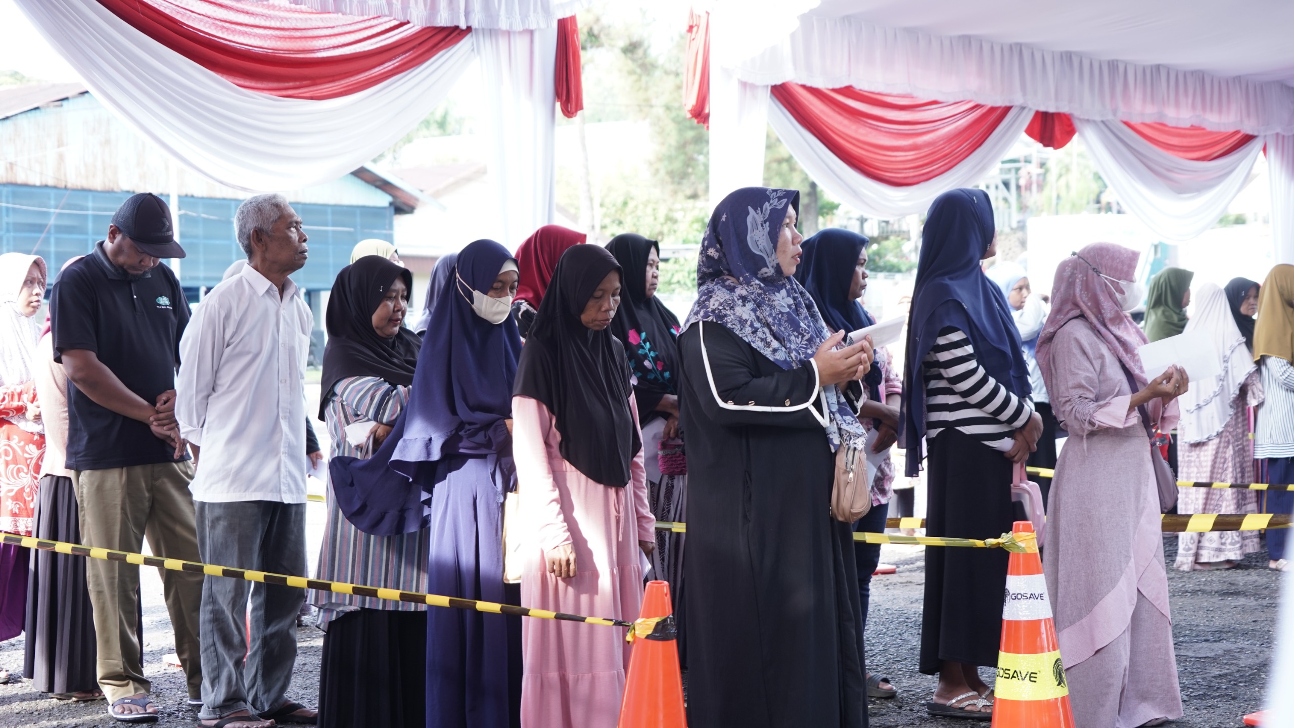 TERTIB: Masyarakat antre mendapatkan paket sembako murah di pasar murah PLN.