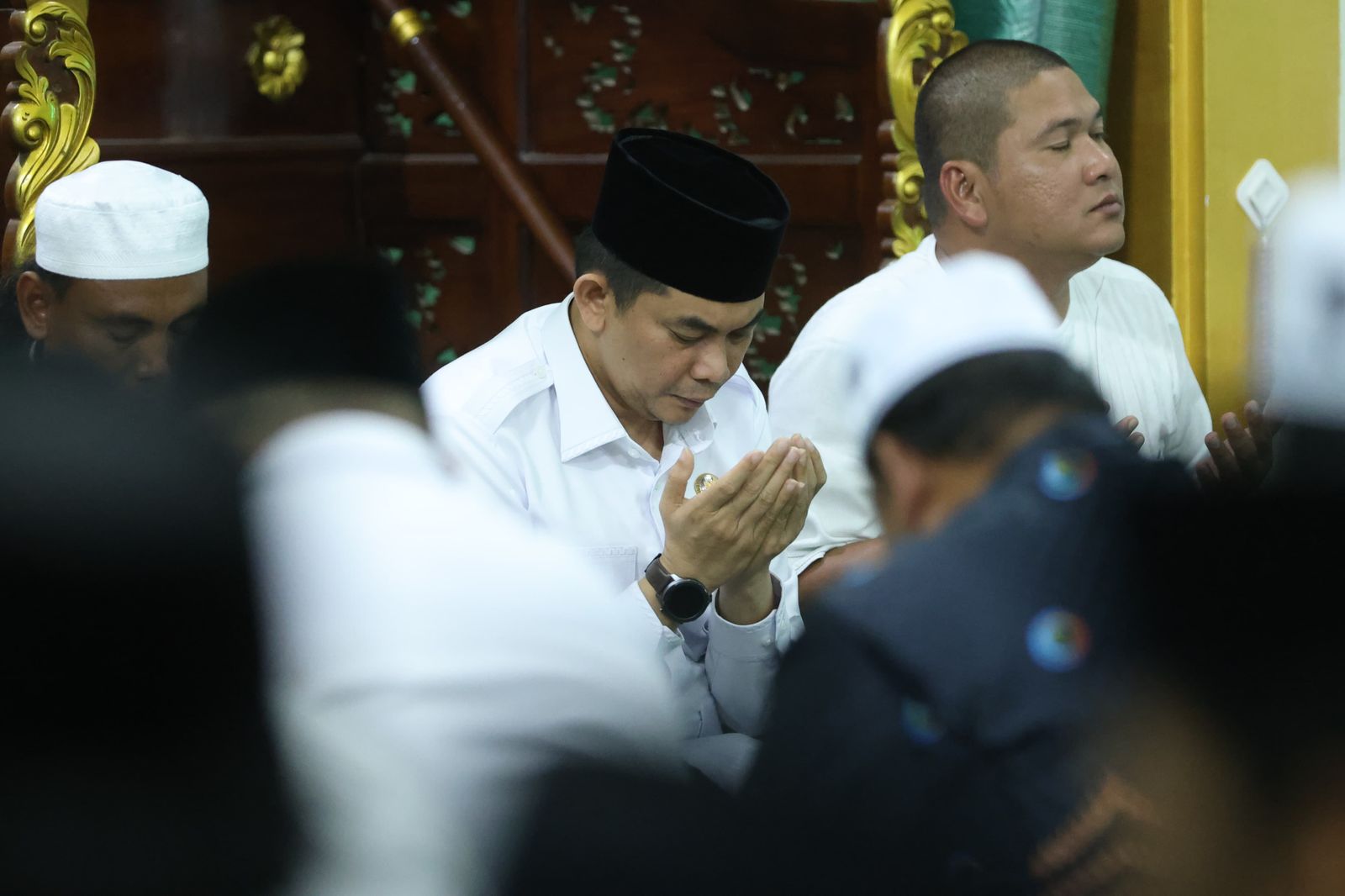 BERDOA: Bupati Tanah Bumbu, Andi Rudi Latif, menundukkan kepala dalam doa bersama usai buka puasa di Masjid Al-Istiqomah, Desa Mantewe.