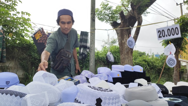 BUKA LAPAK: Husin menyusun peci dagangannya dengan rapi di lapaknya, di Jalan Trikora, seberang Masjid Agung Al-Munawwarah, Jumat (21/3) pagi.