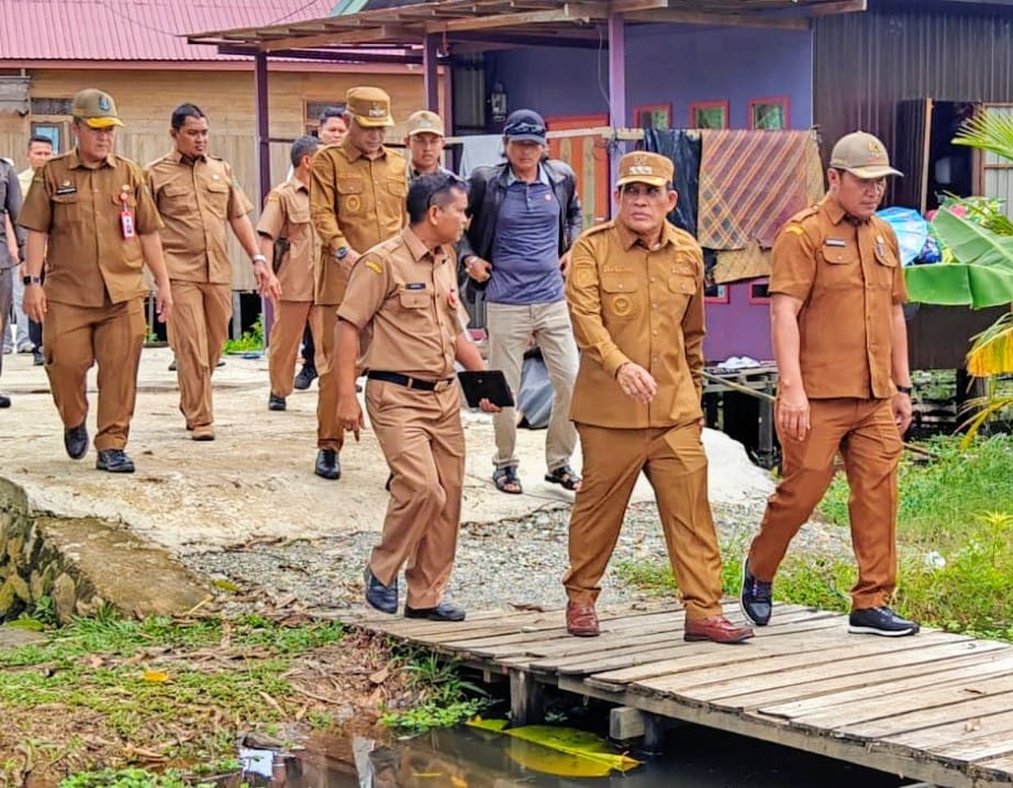 BLUSUKAN: Bupati HSU Sahrujani dan Wabup Hero Setiawan memboyong sejumlah pejabat meninjau kemacetan Pasar Bitin, rencana tanggul penahan banjir dan alternatif jalan. (Foto: M Akbar/Radar Banjarmasin)