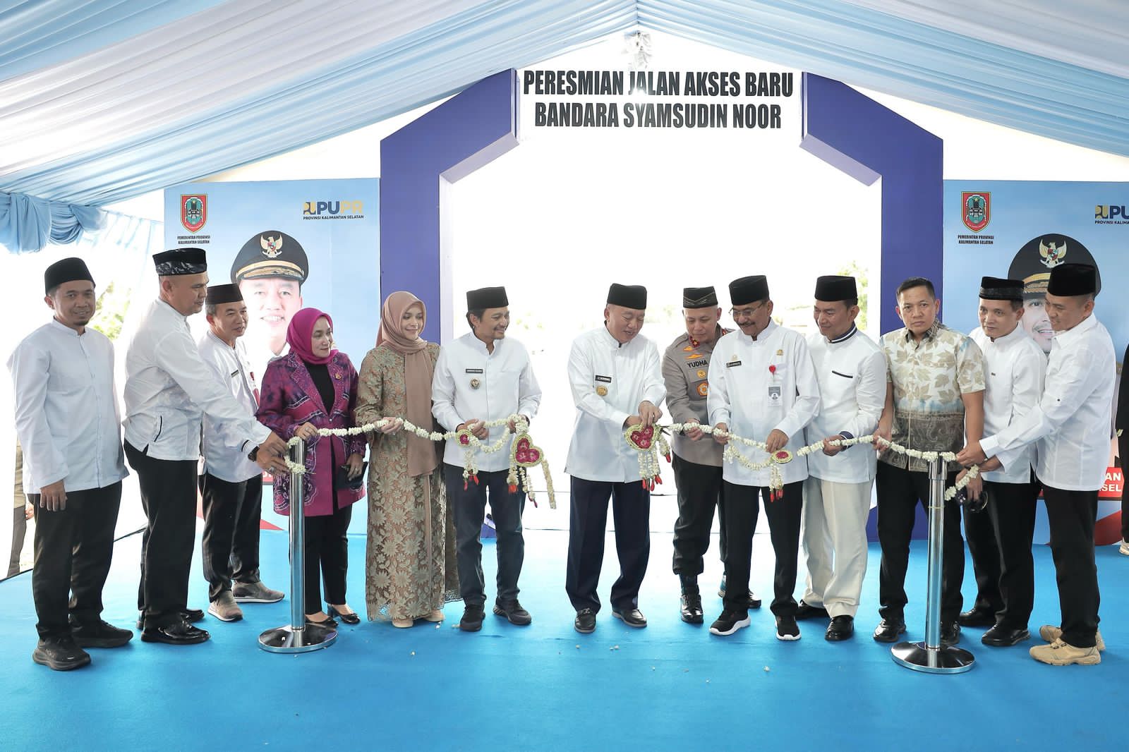 GUNTING KEMBANG:Ketua DPRD Kalsel, H Supian HK (lima dari kiri) ikut memotong pita bunga melati menandai diresmikannya jalan baru akses Bandara Syamsudin Noor.(Foto:Humas DPRD Kalsel)
