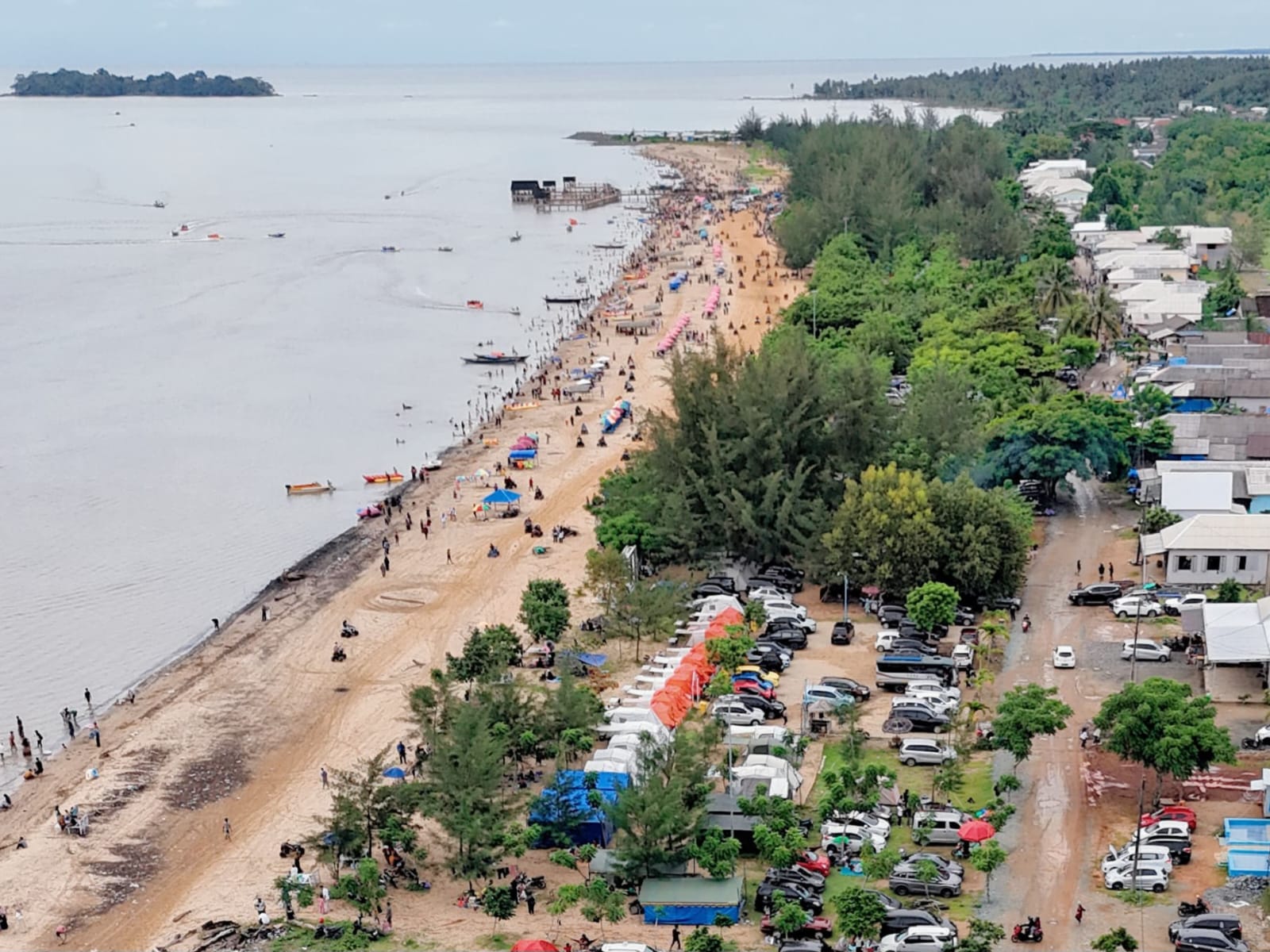 LEBIH RAMAI : Suasana penampakan wisatawan yang mengunjungi Pantai Batakan Baru dari udara. (Foto : Khairil Fahmi untuk Radar Banjarmasin).