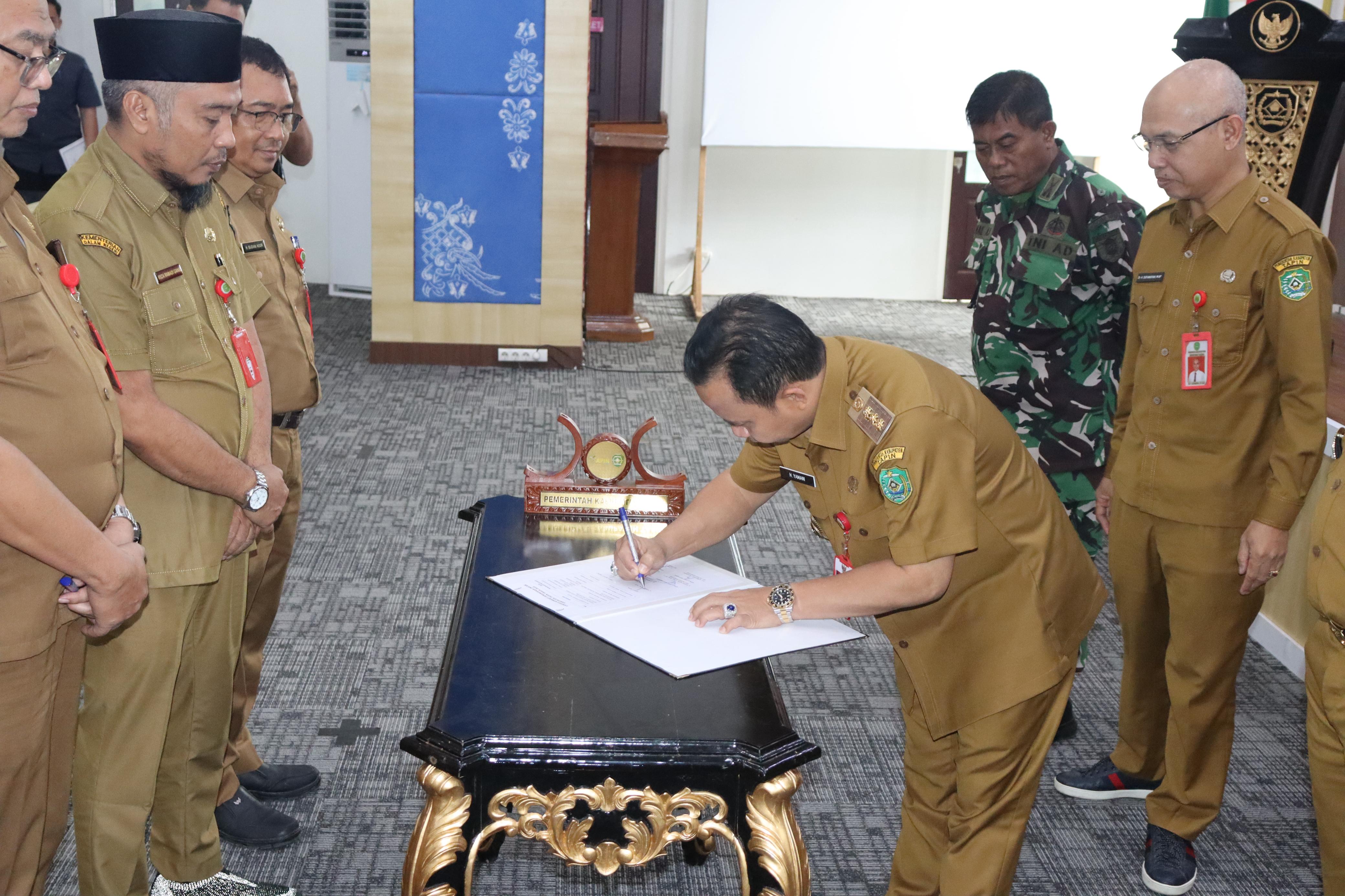 TANDATANGAN: Bupati Tapin H Yamani menandatangani komitmen bersama usai gelar rapat.