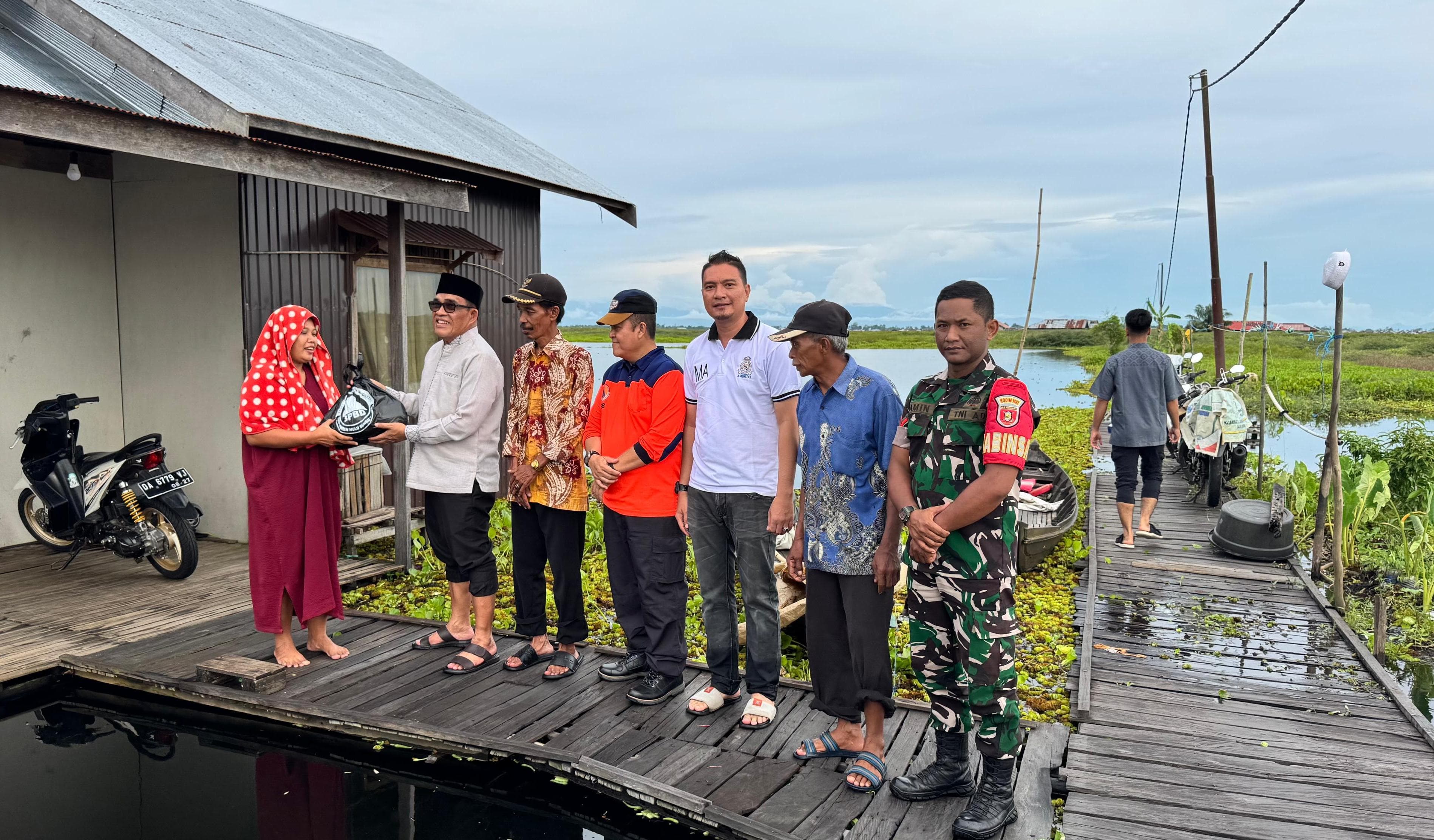 MOMEN:Bupati HSU, H Sahrujani menyerahkan bantuan banjir kepada warga Desa Telaga Mas, di Kecamatan Danau Panggang, Jumat (11/4/2025).