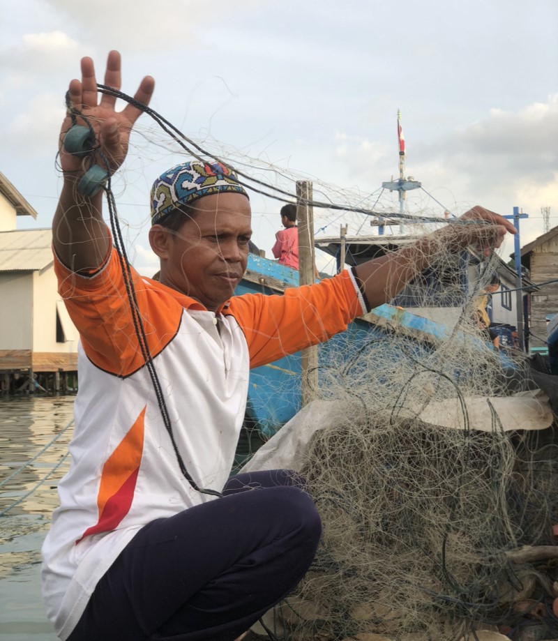 NELAYAN: Hamdani nelayan di Desa Rampa sedang memperbaiki jaring ikannya