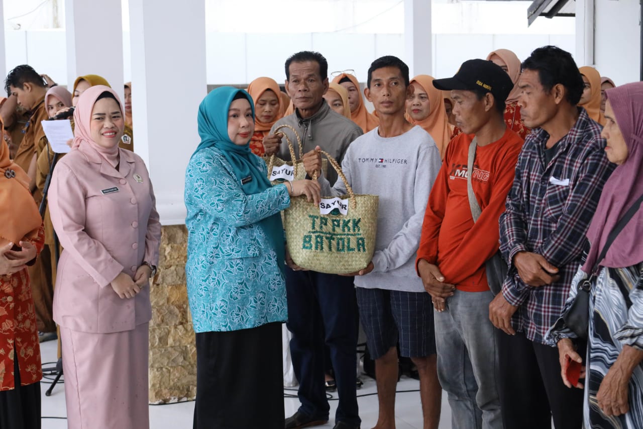 BERBAGI:Ketua TP PKK Batola Hj Noor Hayati menyerahkan paketan sembako.