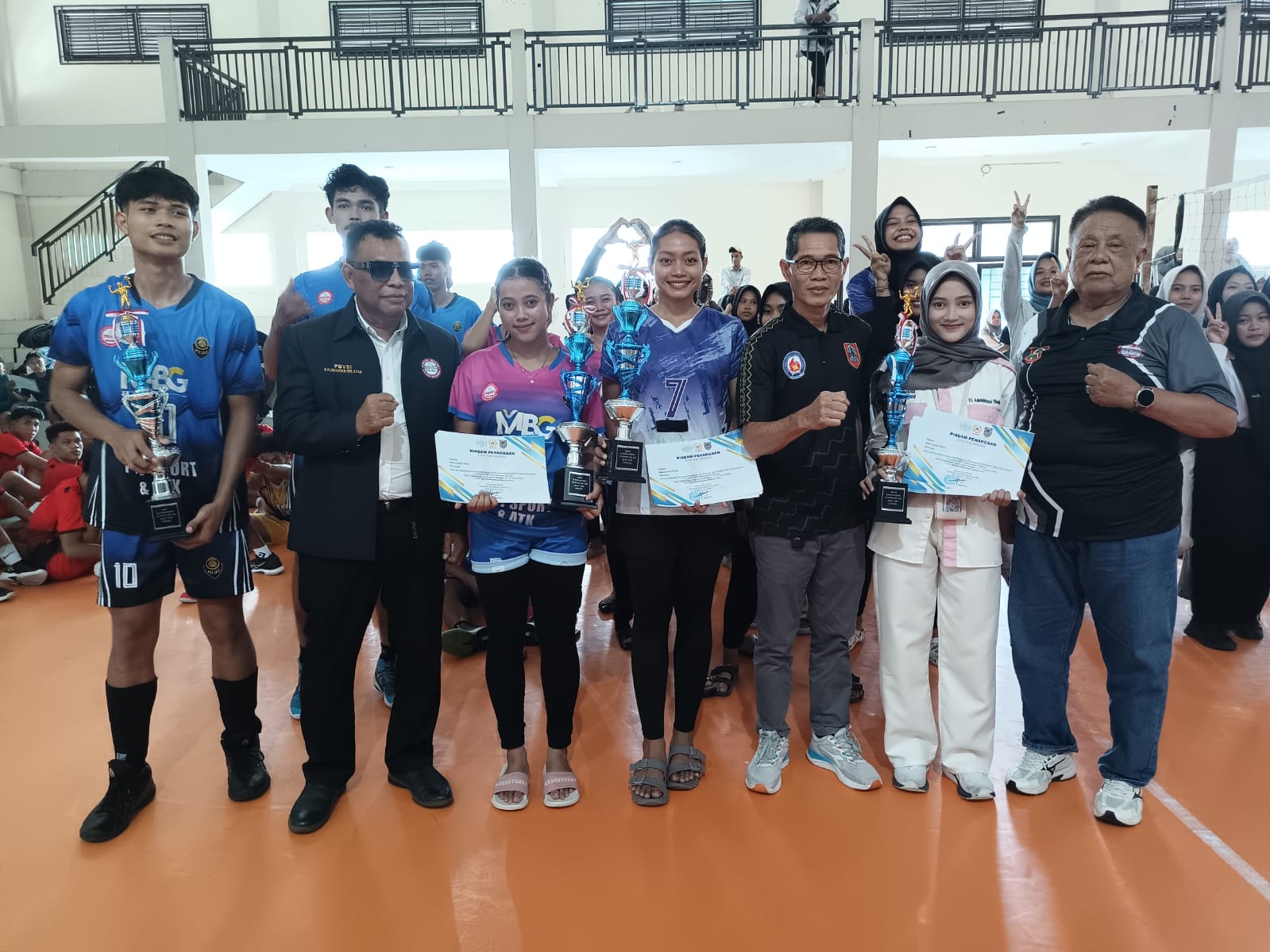 BERPOSE: Skuad voli putra dan putri Tanah Bumbu berpose usai mengawinkan gelar juara di Kejurprov Bola Voli Kalsel 2025, Selasa (15/4), di Gedung SKB Mulawarman, Banjarmasin. (M Idris Jian Sidik)