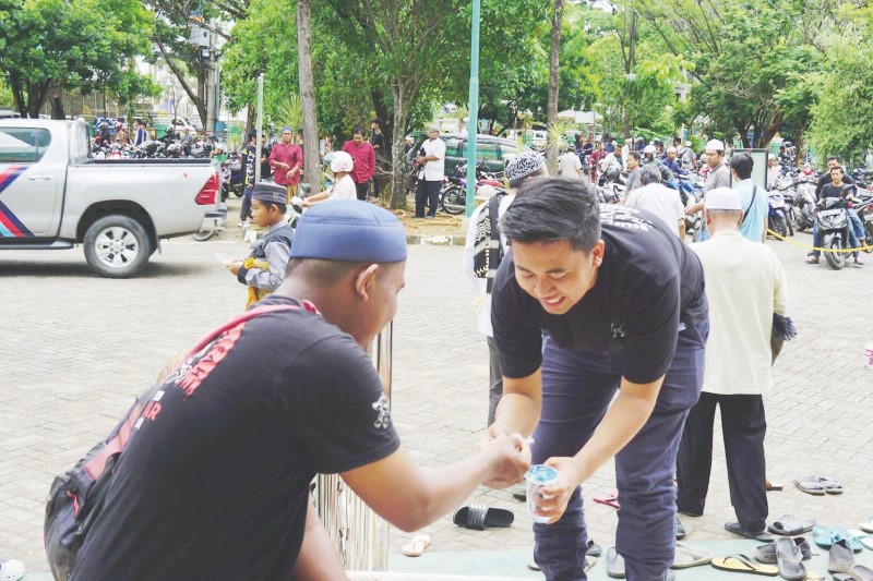BERBAGI: Kegiatan Sedekah 2000 yang membagikan air mineral dan makanan ringan kepada jemaah yang baru selesai menunaikan ibadah Salat Jumat.