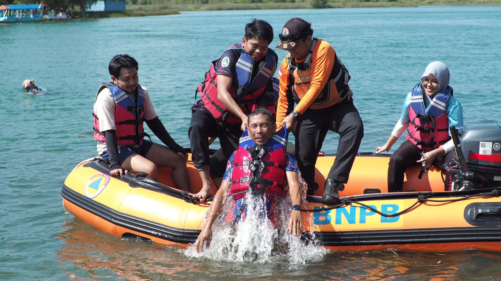 EVAKUASI: Peserta mempraktikkan teknik evakuasi korban dari air menggunakan perahu karet dalam simulasi latihan penyelamatan di Danau Seran, Sabtu (26/4/2025).