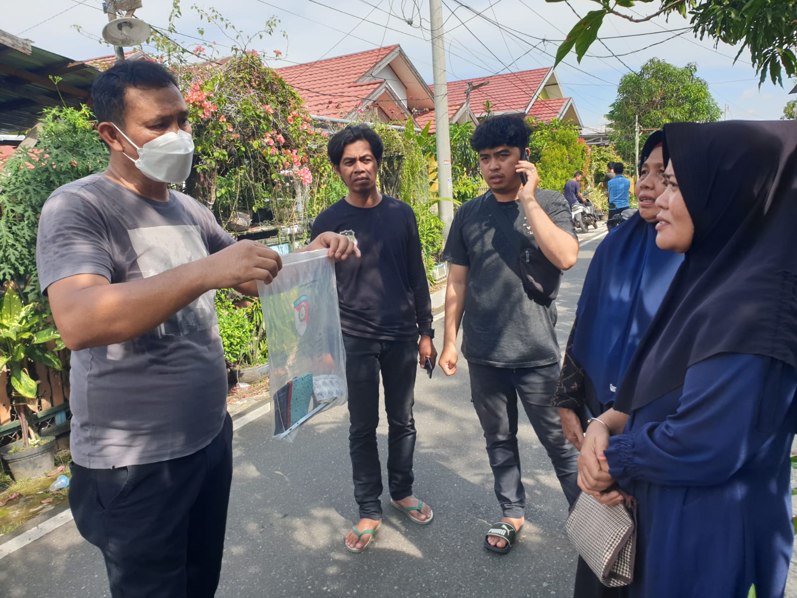 Kanit PPA Satreskrim Polresta Banjarmasin Ipda Partogi Hutahean (kiri) saat berada di TKP rumah tersangka.