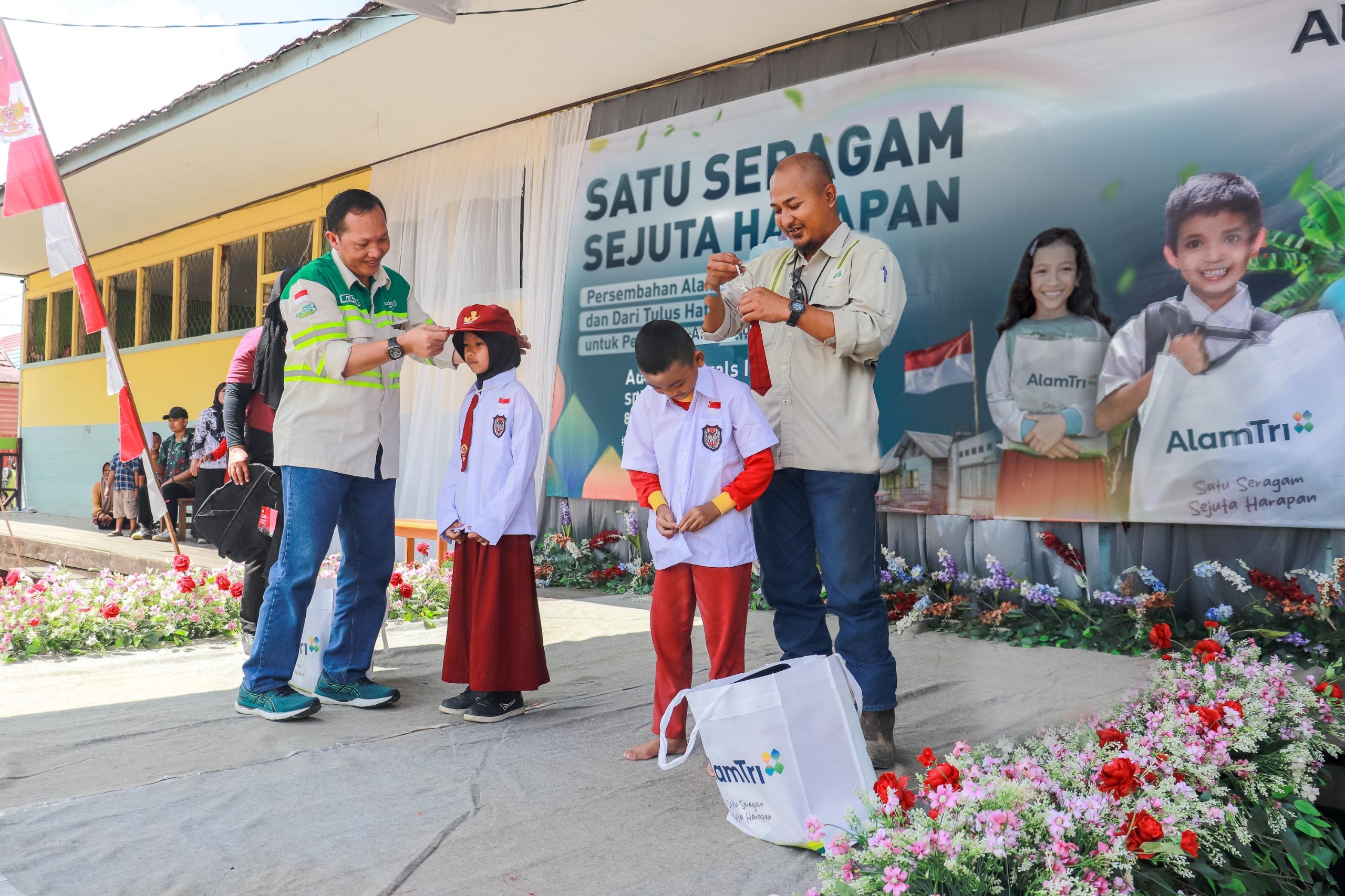 SERAGAM BARU:External Division Head PT Maruwai Coal, Ferry Basrah memakaikan seragam sekolah baru ke salah seorang perwakilan siswa SDN 1 Muara Tuhup.