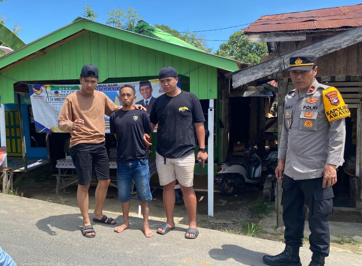 TAK BISA MENGELAK: SY dikawal polisi yang meringkusnya. Ia diduga sebagai kurir narkoba di kawasan simpang tiga Pasar Awayan. (Foto: Lulus untuk Radar Banjarmasin)