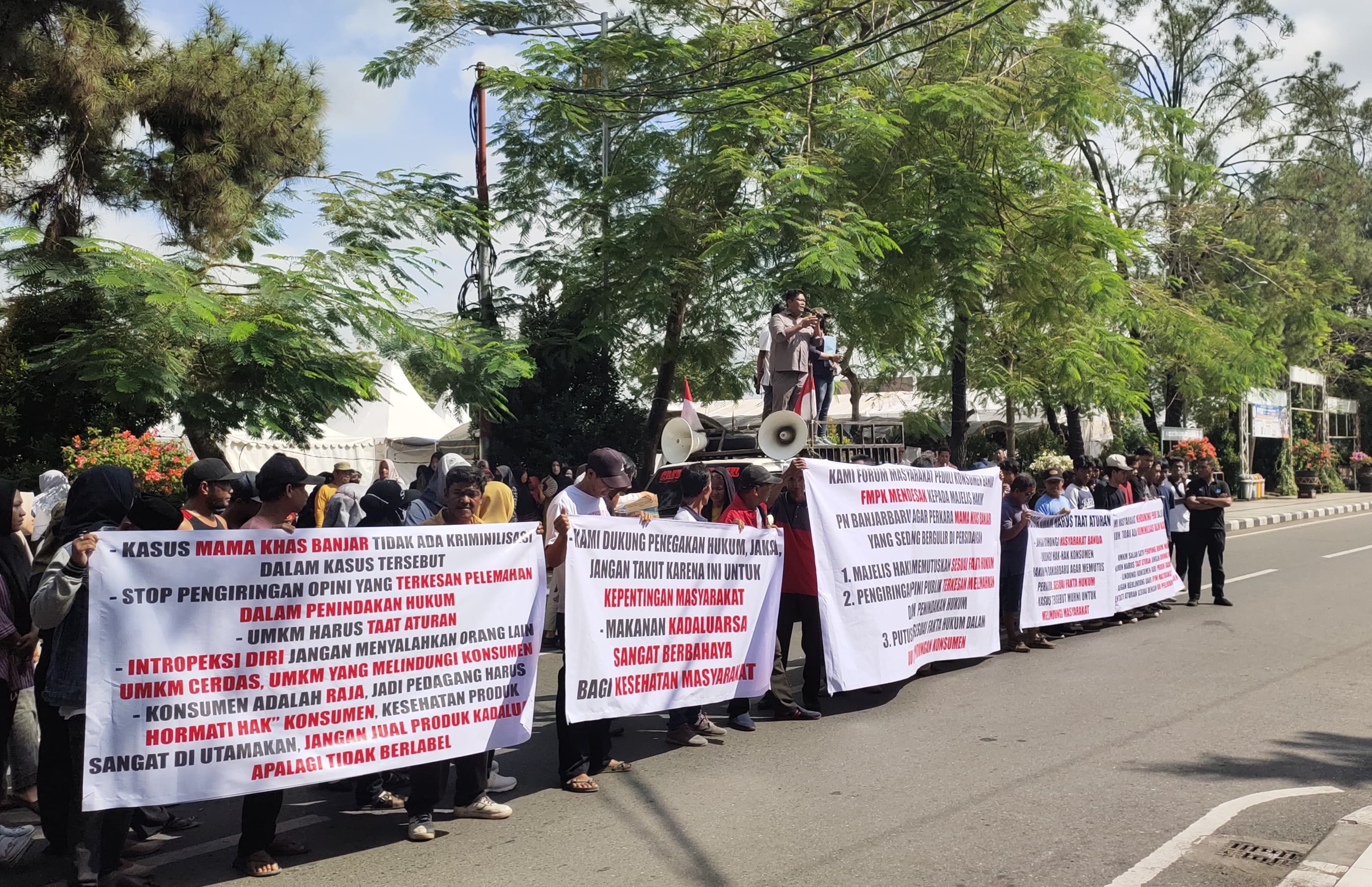 AKSI WARGA: Massa dari FMPKB gelar aksi di depan gedung DPRD Banjarbaru, Rabu (14/5), desak netralitas hukum kasus Mama Khas Banjar. (Bayu/Radar Banjarmasin)